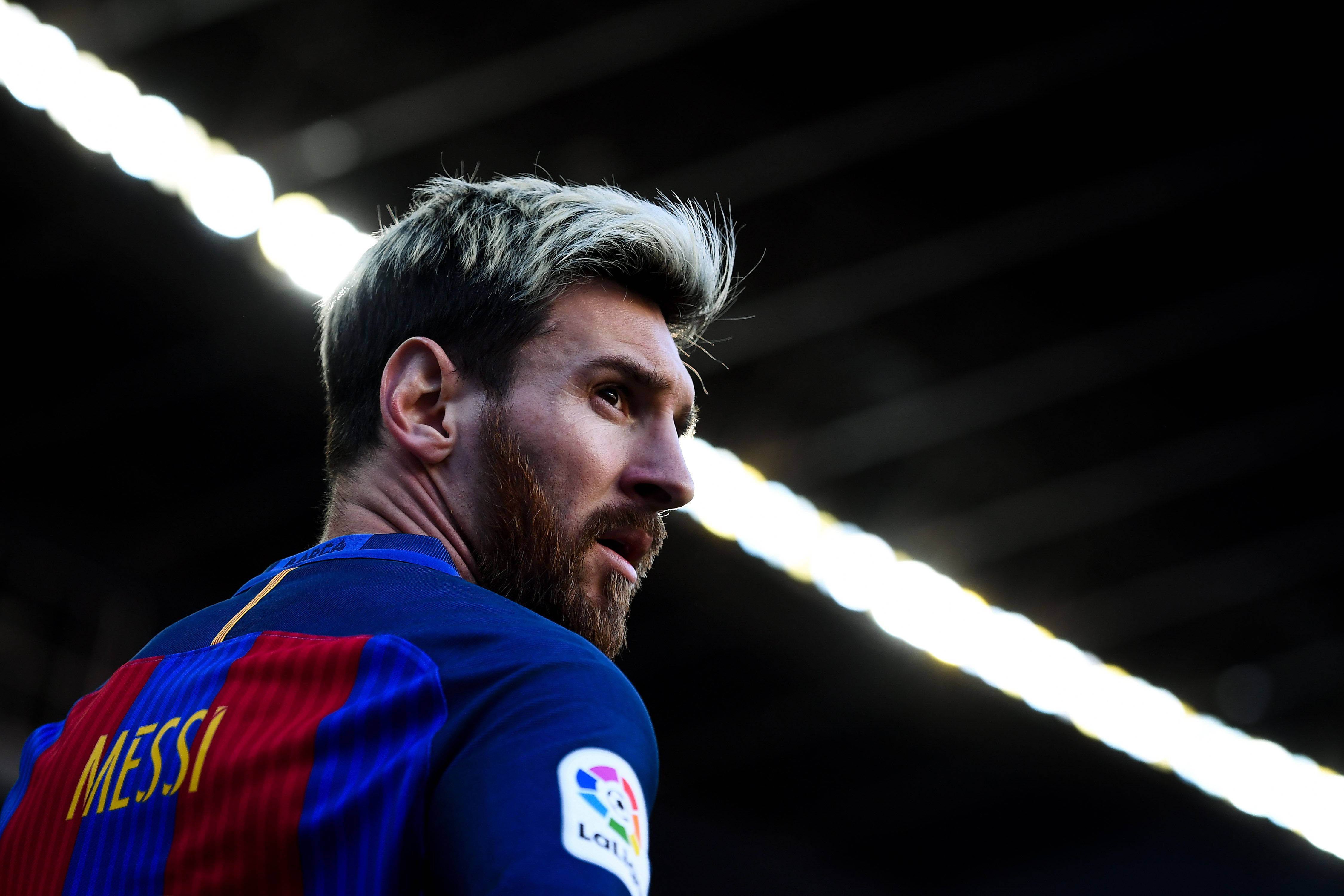 Messi 4K Ultra HD 桌布 壁紙 — 里奧內爾·梅西身穿藍紅條紋球衣，在球場燈光下專注地向前凝視的特寫。