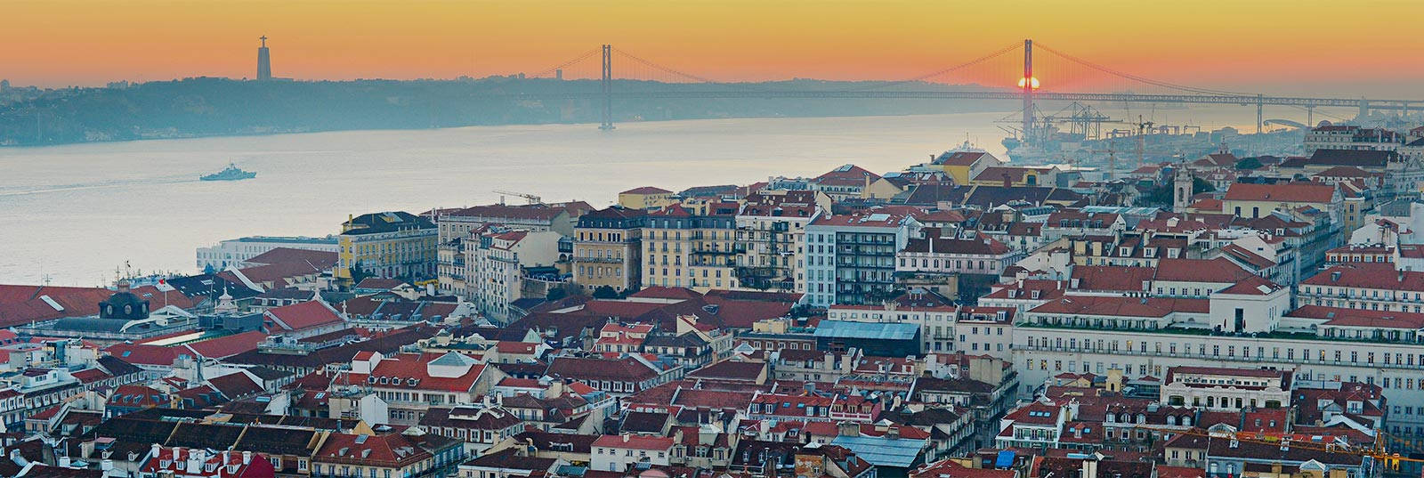 Portugal 桌布 壁紙 — 里斯本歷史城區的 panoramic 日落景觀，紅瓦屋頂和橫跨特茹河的 4 月 25 日大橋。