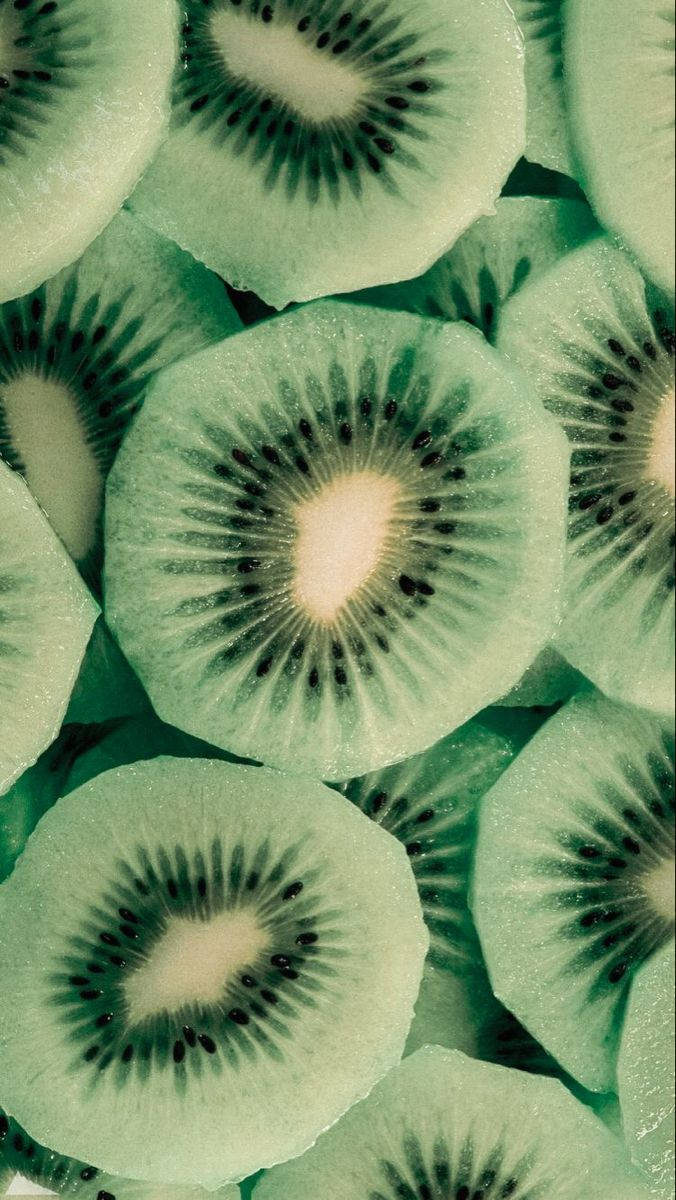淺綠色系 桌布 壁紙 — 重疊奇異果切片的特寫，展現多汁綠色果肉和黑色種子，形成鮮明圖案。