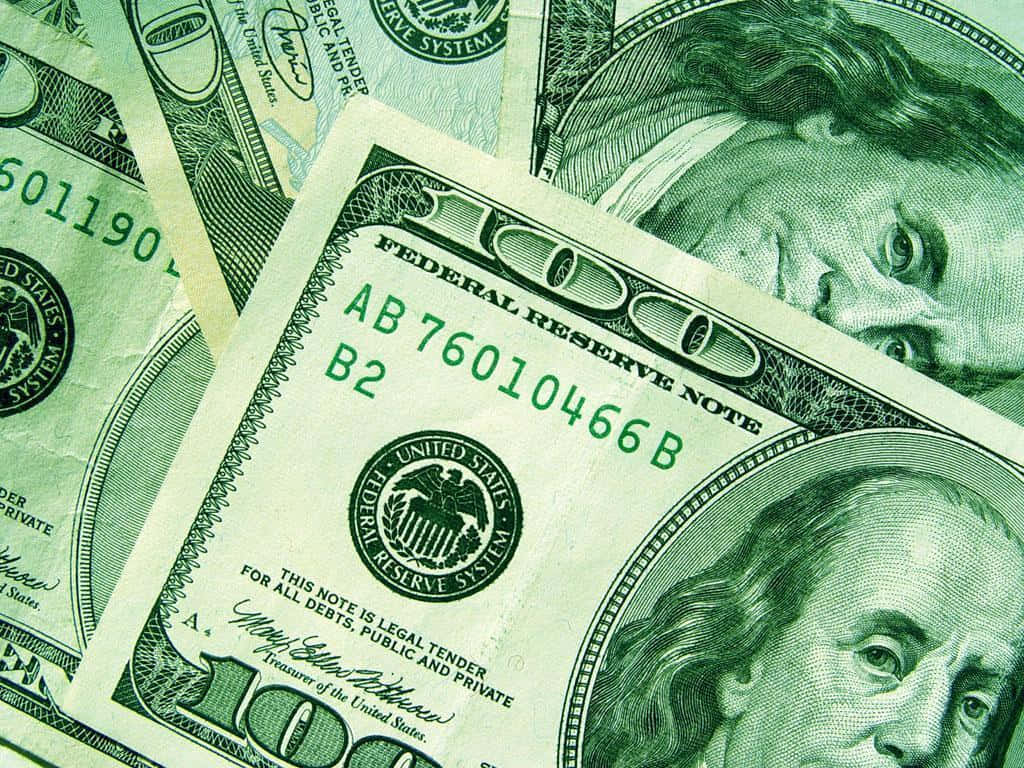 Money 桌布 壁紙 — 重疊的美國一百美元鈔票特寫，顯示班傑明·富蘭克林的肖像和綠色墨水細節。