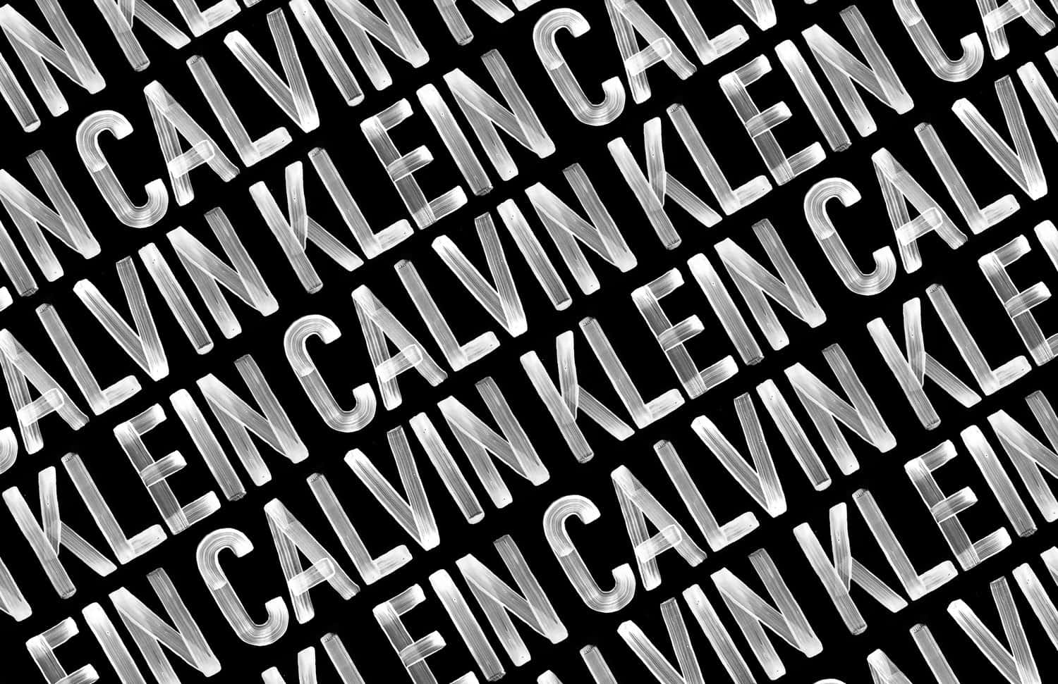 斜向重複的 Calvin Klein 標誌文字以白色書法字體呈現在黑色背景上。 — Valorant Logo 壁紙