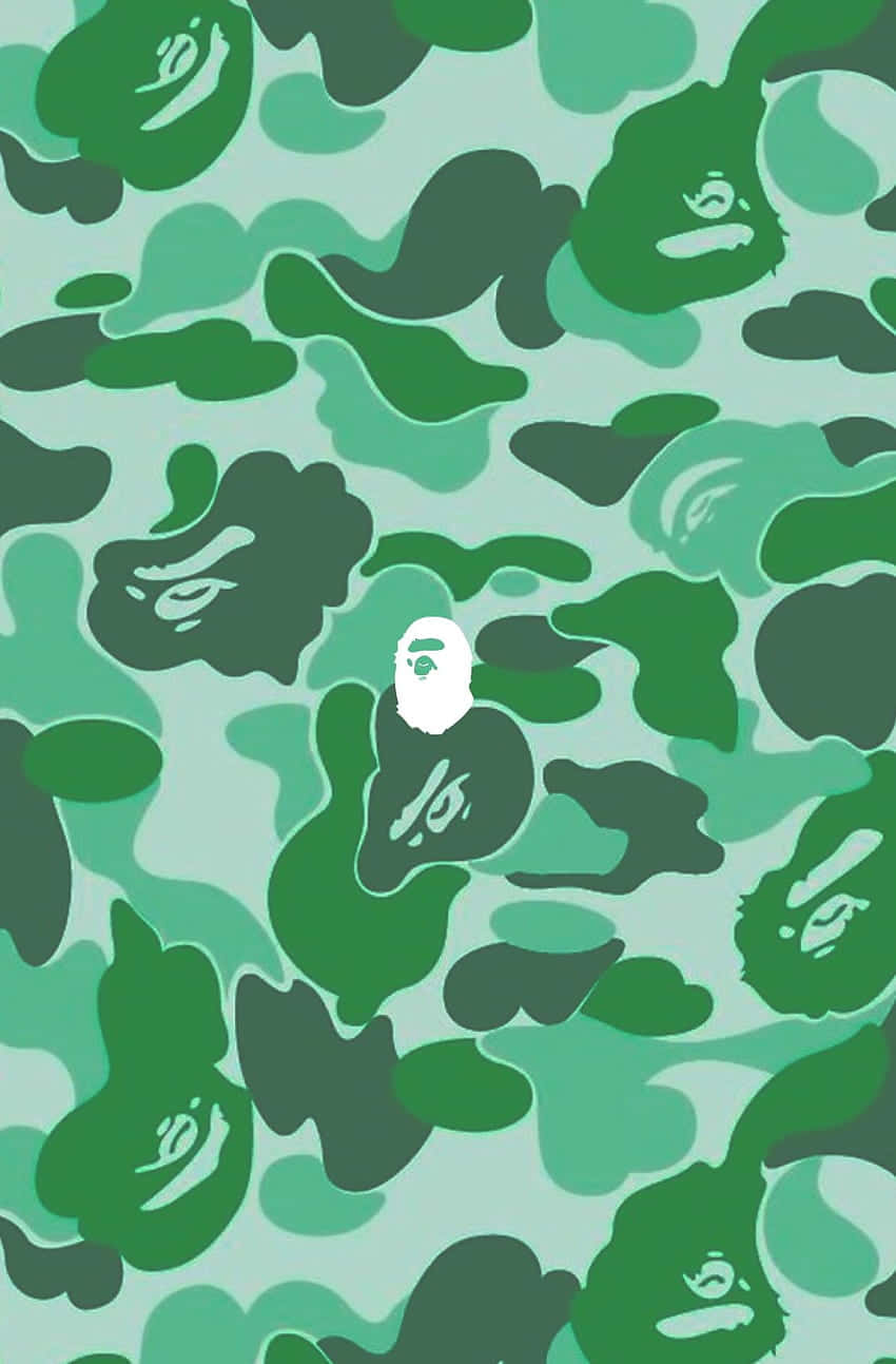 Bape 動態 桌布 壁紙 — 重複的綠色迷彩圖案，帶有風格化的猿臉，中央有一個白色猿頭。
