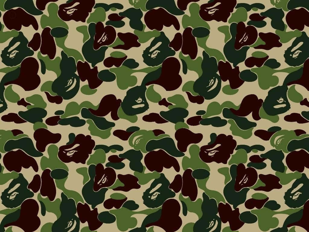 Bape Camo 桌布 壁紙 — 重複的迷彩圖案，帶有深綠色、棕色和米色斑點，並呈現風格化的猿臉。