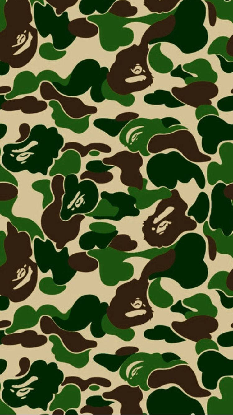 Bape 動態 桌布 壁紙 — 重複的迷彩圖案，帶有綠色、棕色和米色形狀，並有風格化的猿臉。