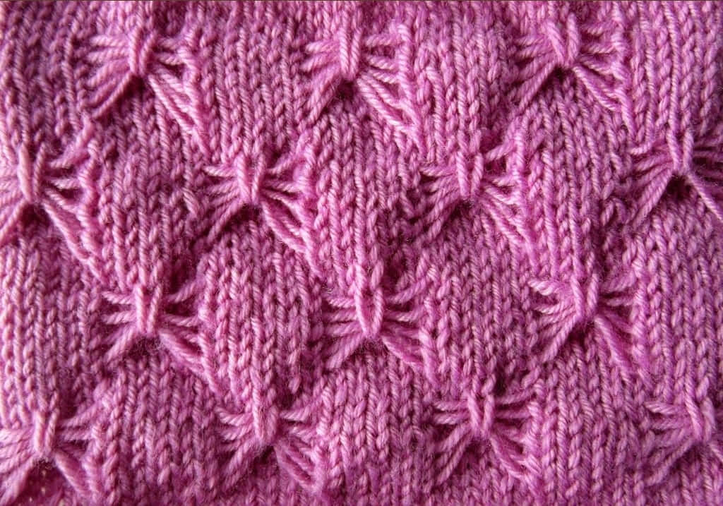 Butterfly Stitch 桌布 壁紙 — 重複葉狀紋理圖案的複雜粉紅色針織布料的特寫。
