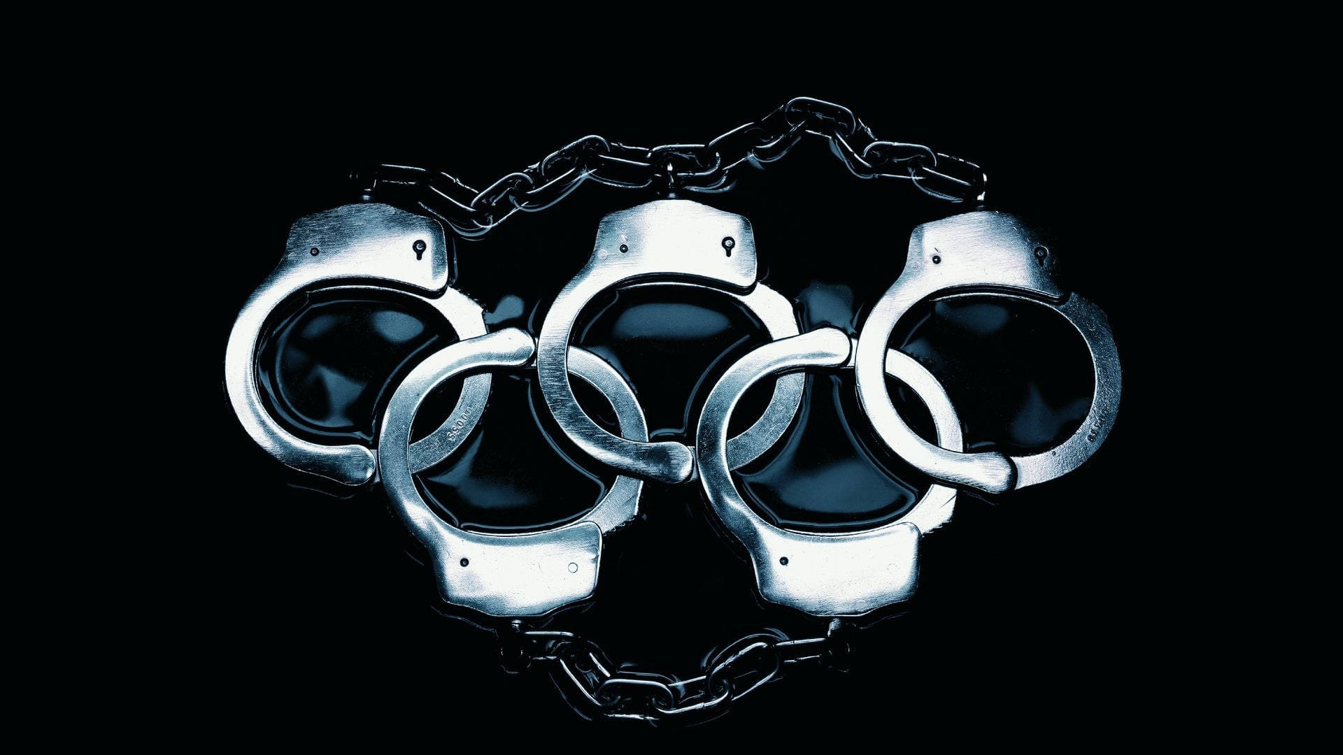 Olympics 桌布 壁紙 — 金屬手銬在純黑背景上形成奧運五環，帶有戲劇性燈光。