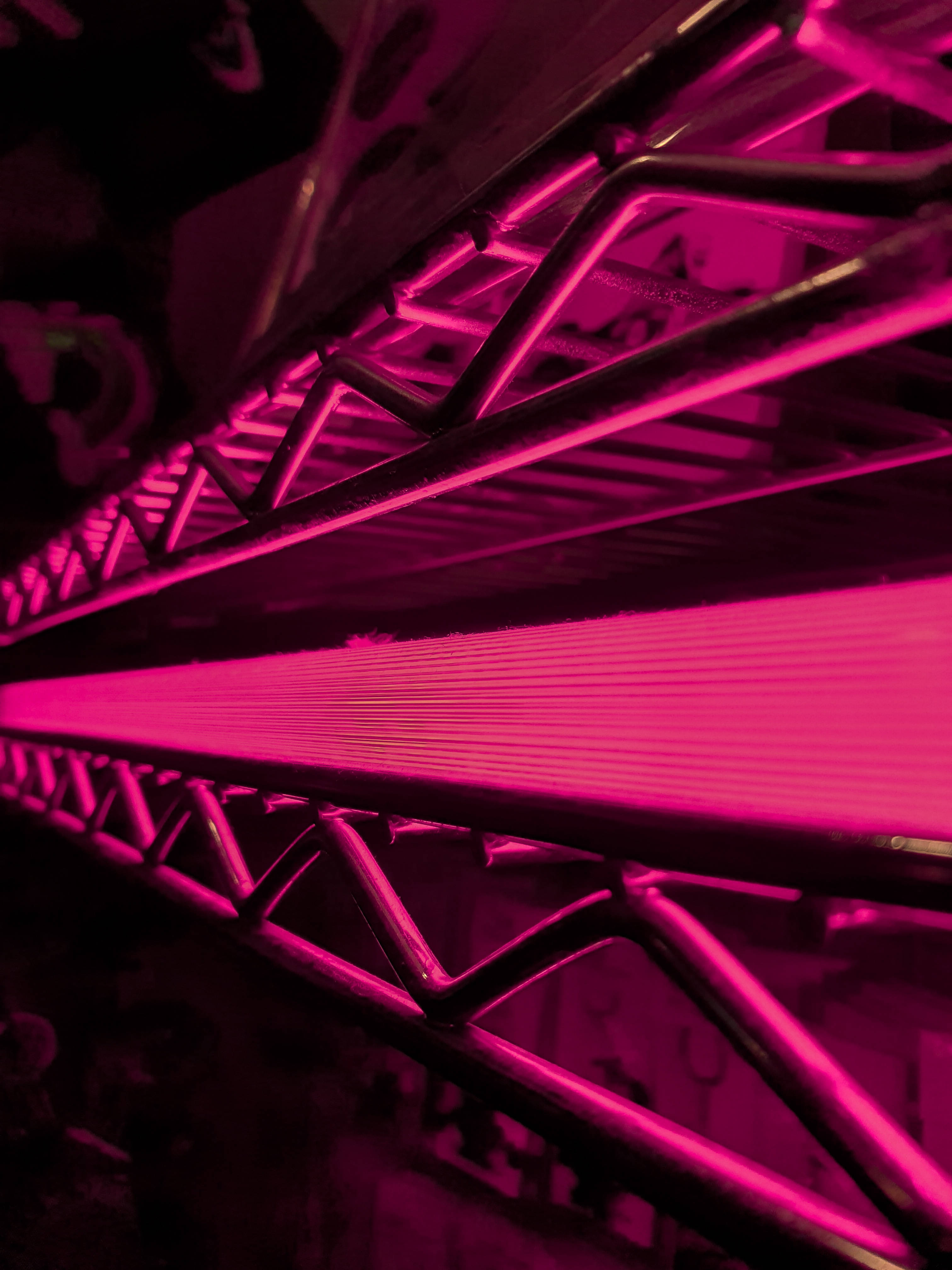 Magenta 桌布 壁紙 — 金屬桁架結構的特寫，沐浴在強烈的洋紅色光線中，營造出未來主義的工業氛圍。