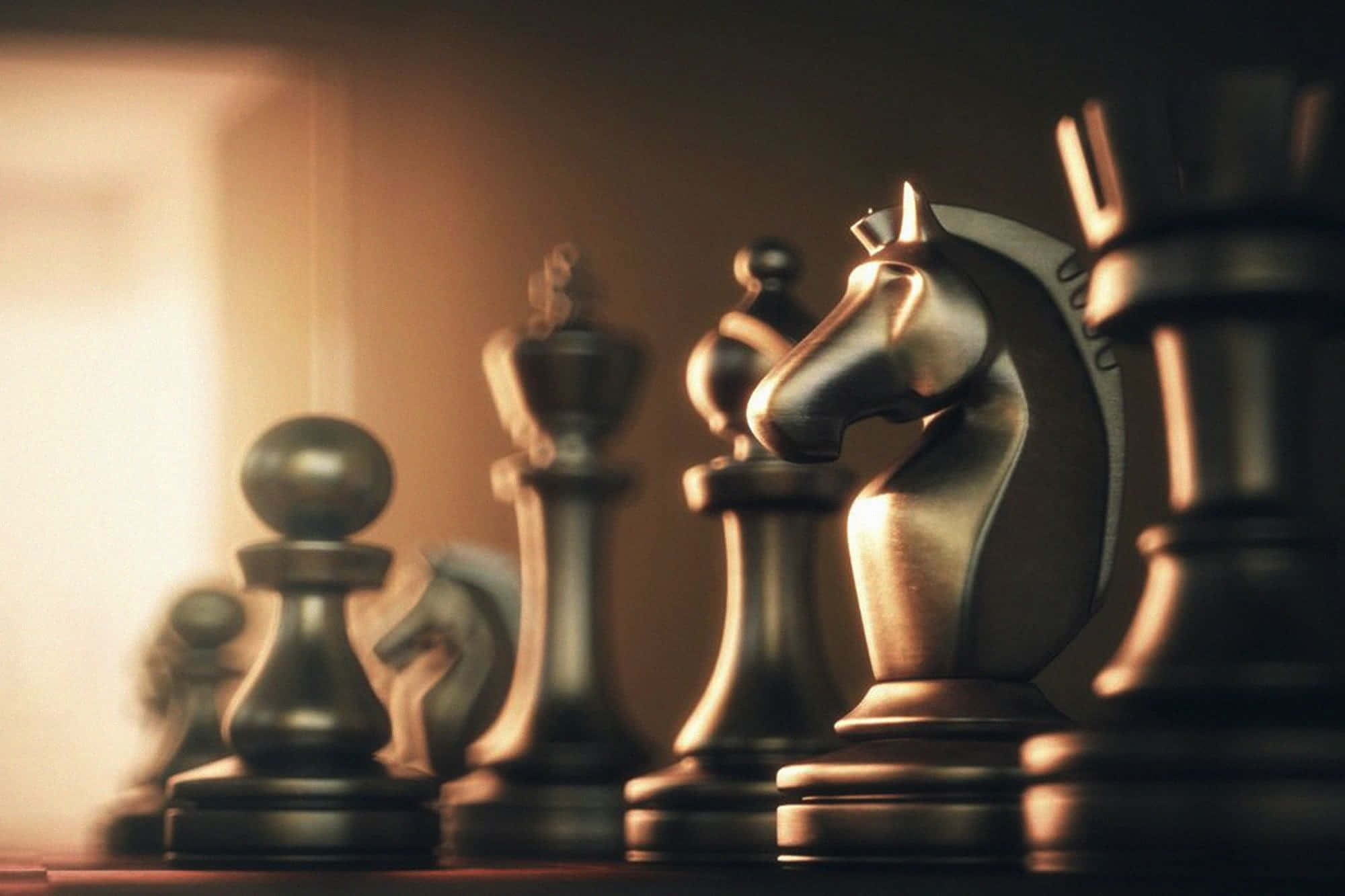 Educational Games 桌布 壁紙 — 金屬西洋棋棋子的特寫，沐浴在溫暖的金色光線中，景深較淺。