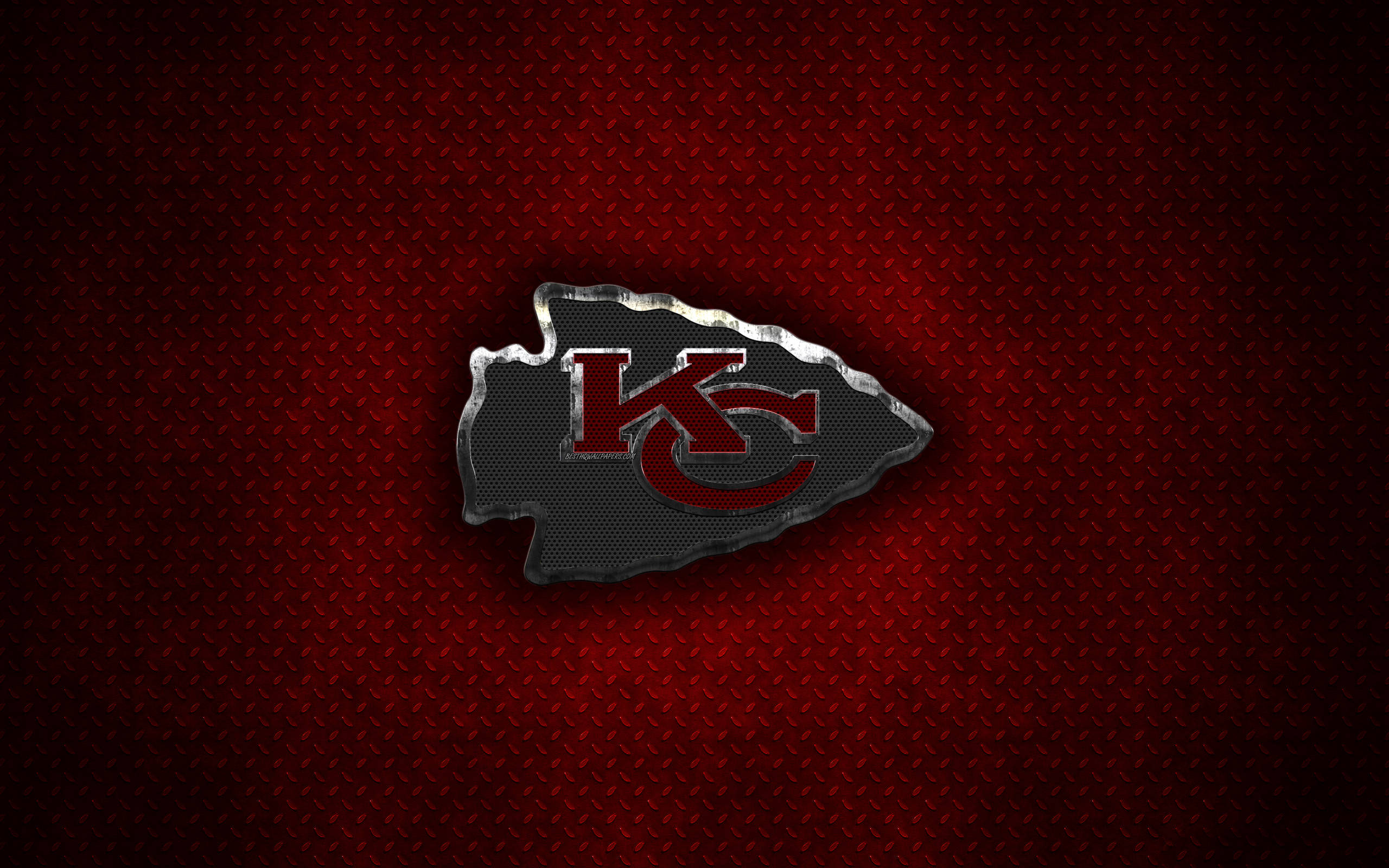 Kansas City Chiefs Logo 桌布 壁紙 — 金屬質感的堪薩斯城酋長隊標誌在帶紋理的紅色菱形板背景上閃耀。
