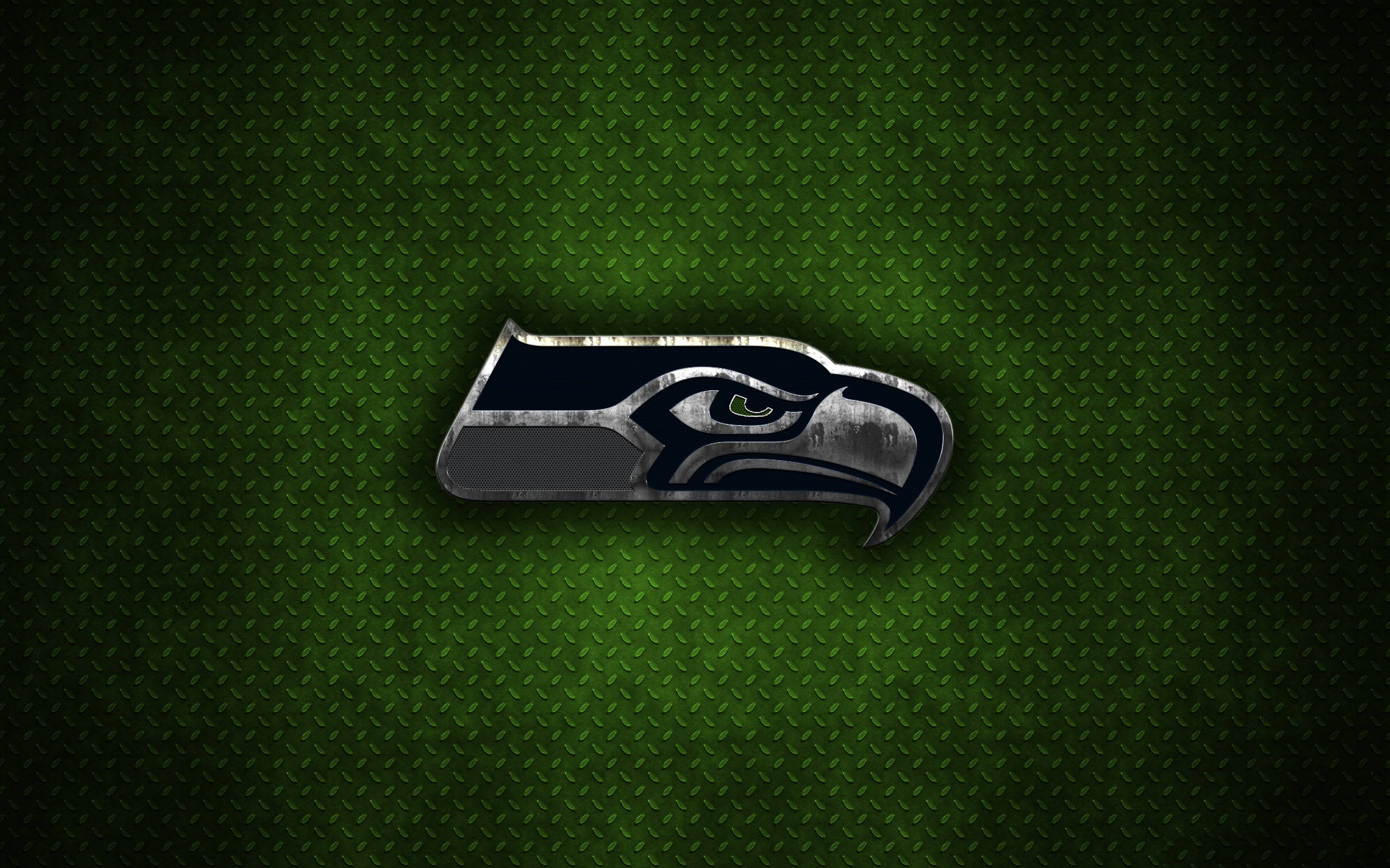 Seattle Seahawks 桌布 壁紙 — 金屬質感的西雅圖海鷹隊標誌在帶紋理的深綠色菱形板背景上閃耀。