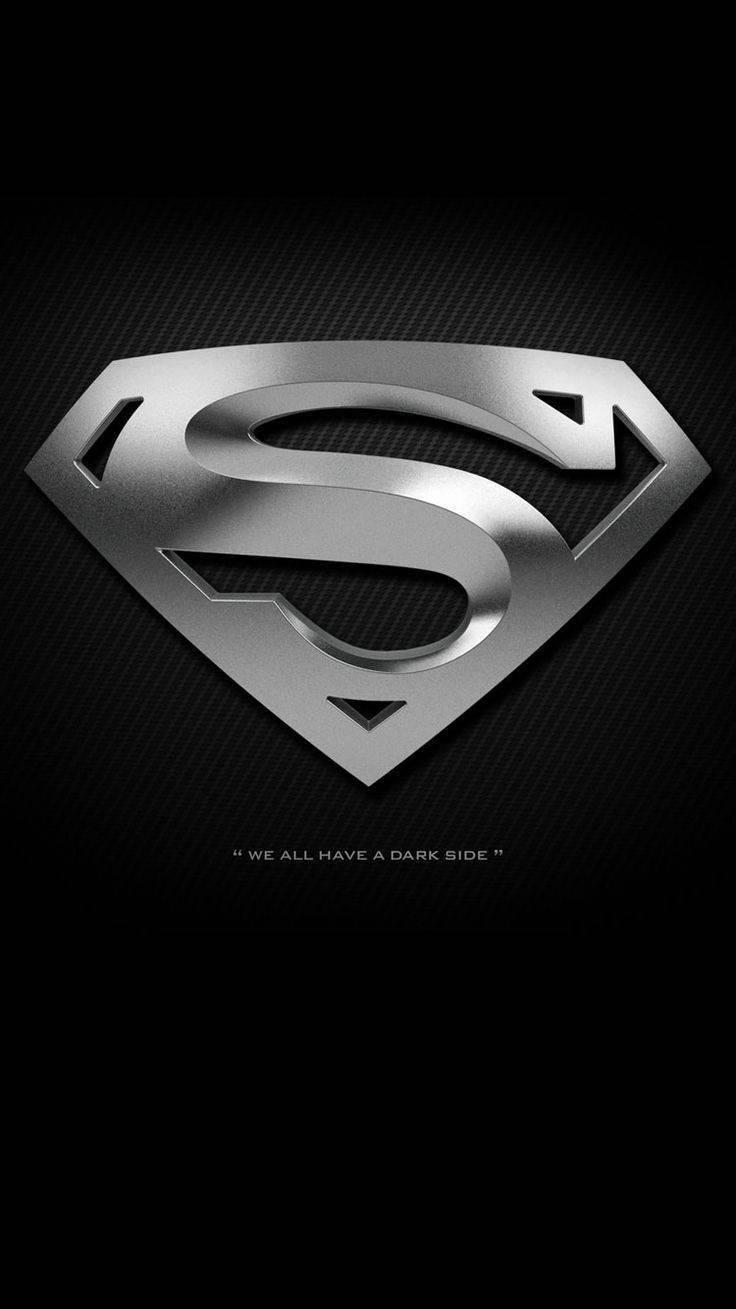 superman symbol iPhone 桌布 壁紙 — 金屬銀色超人標誌在帶有紋理的黑色碳纖維背景上閃耀，下方有深色引言。