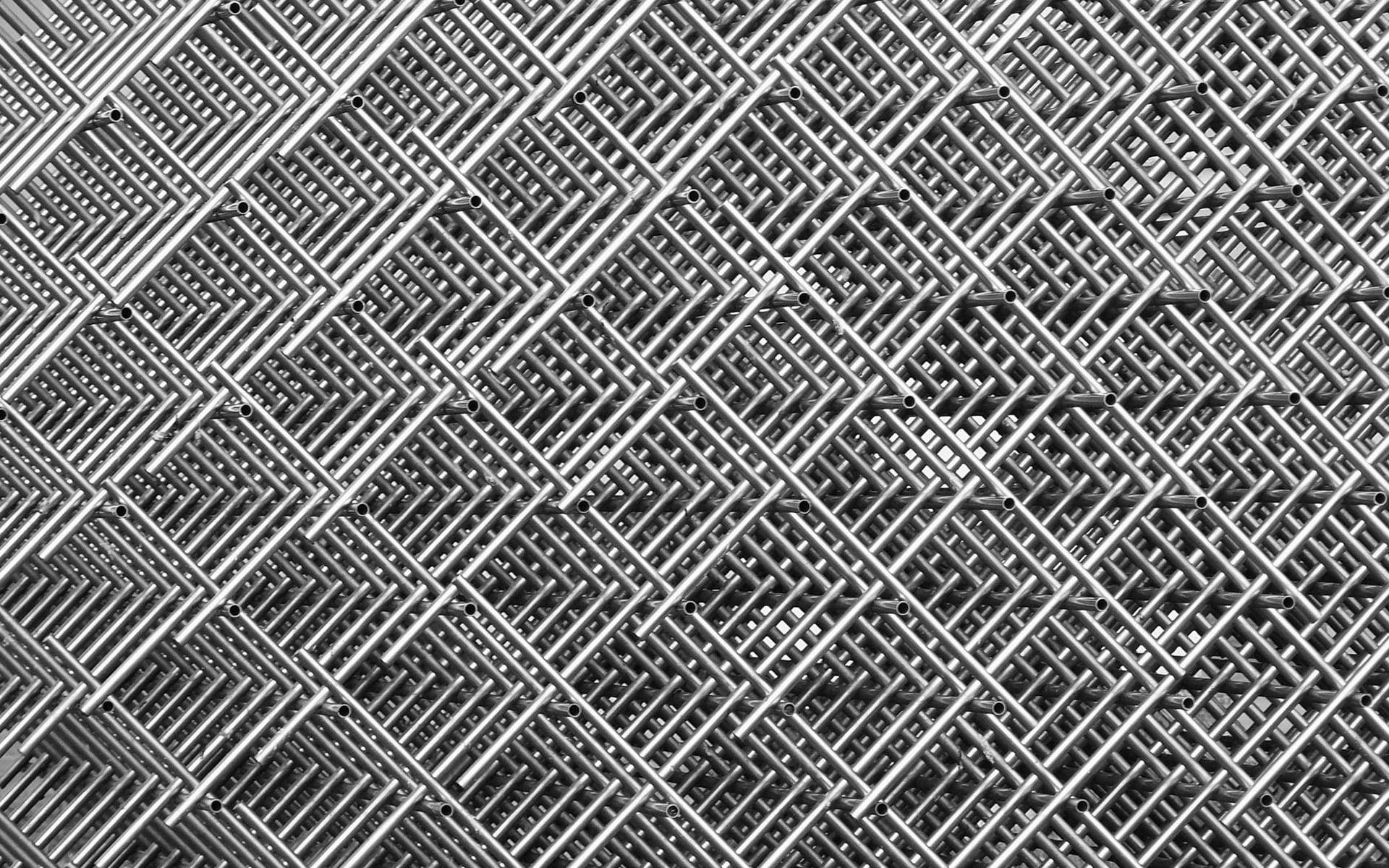 black and white aesthetic grid 桌布 壁紙 — 金屬鏈條圍欄的特寫，帶有重複的菱形圖案和工業光澤。