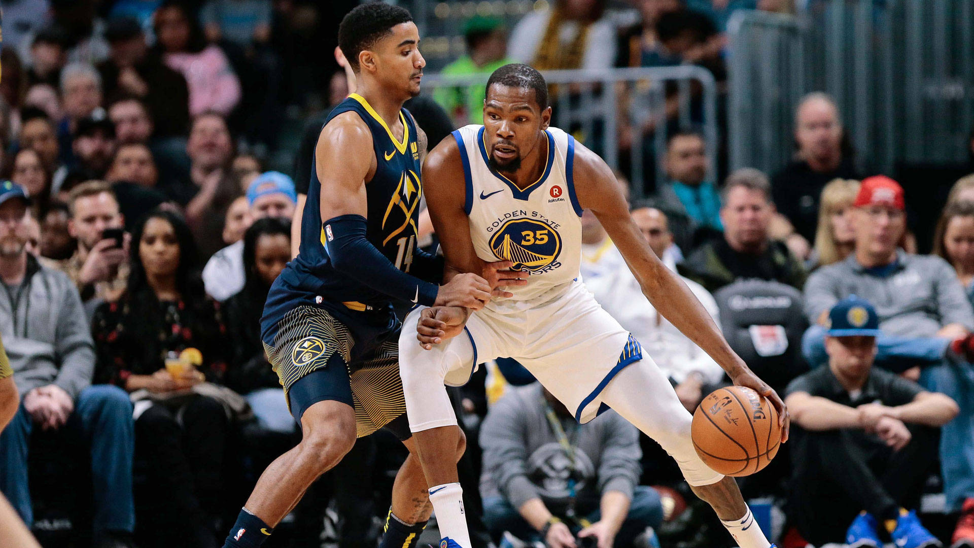 gary harris 桌布 壁紙 — 金州勇士隊35號球員在擠滿觀眾的籃球比賽中運球，同時被對方球員緊密防守。