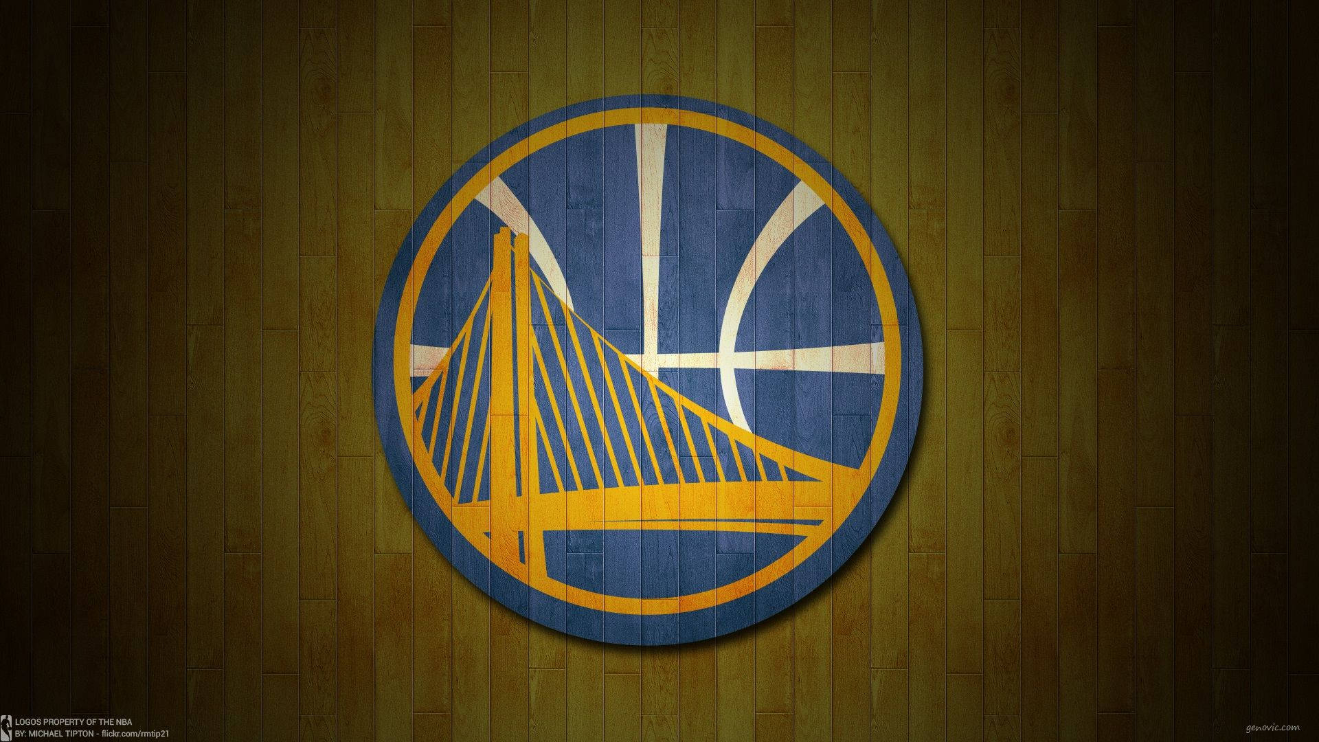 Warriors 桌布 壁紙 — 金州勇士隊標誌繪在木製籃球場地板上，帶有溫暖的環境燈光。