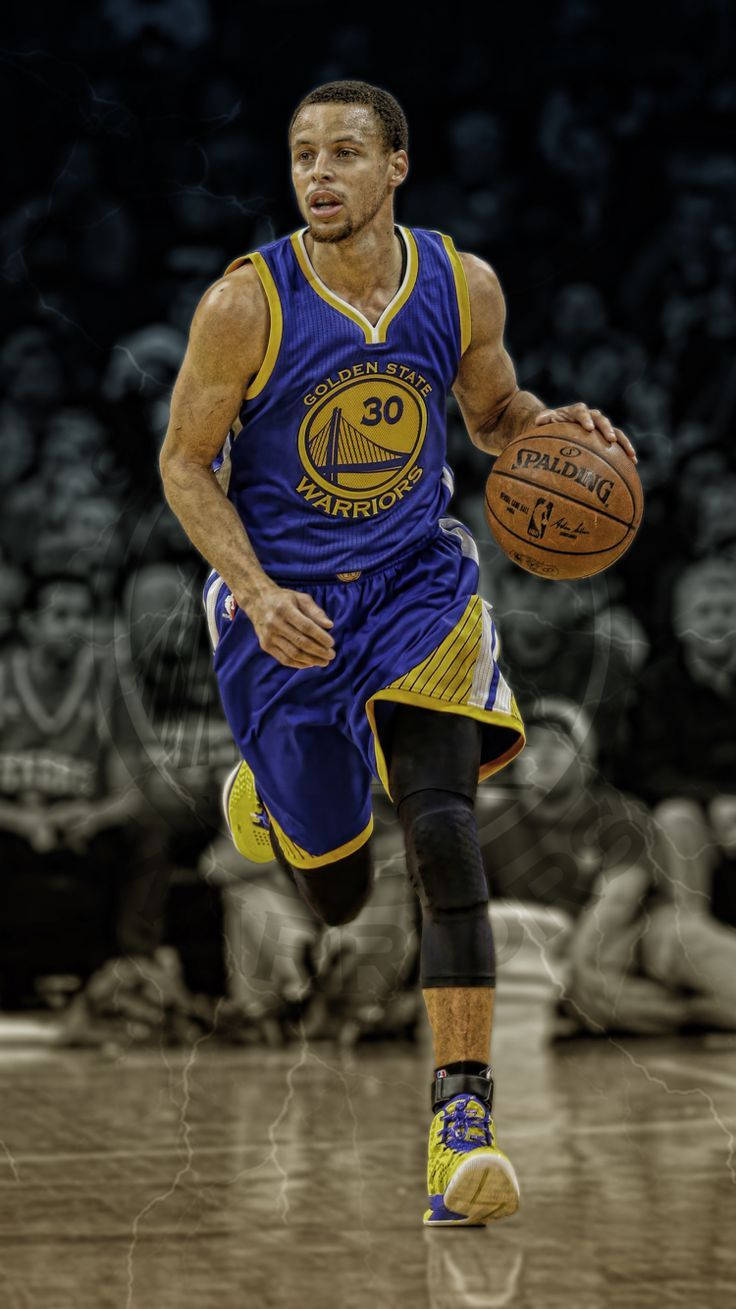 Curry 桌布 壁紙 — 金州勇士隊球員史蒂芬柯瑞在比賽中運球移動，背景是模糊的人群。