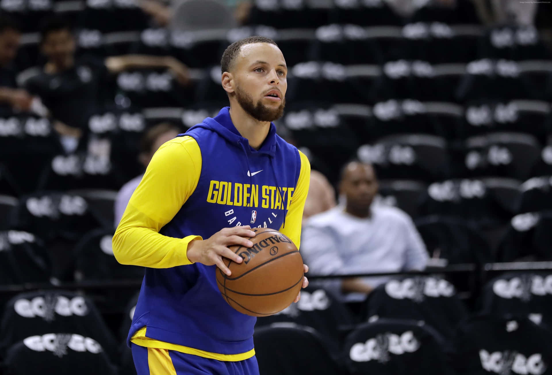 史蒂芬柯瑞身穿金州勇士隊裝備，在球場上拿著籃球。 — NBA 壁紙