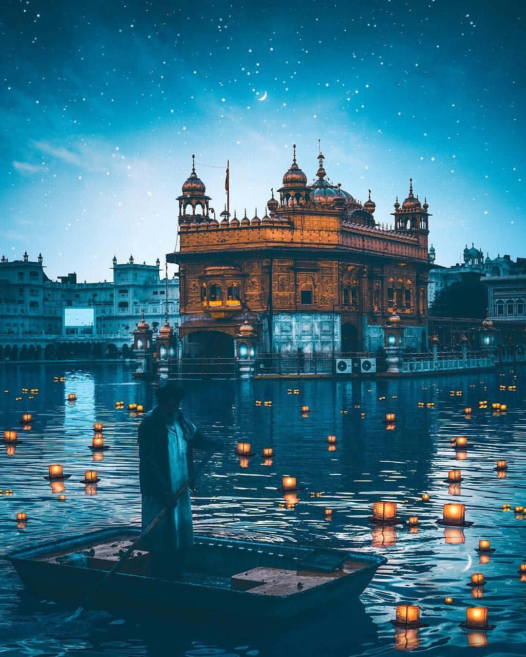 建築 桌布 壁紙 — 金廟的寧靜夜景，船夫在繁星點點的天空和彎月下划過漂浮的燈籠。