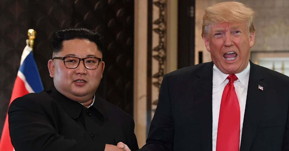 Kim Jong Un 桌布 壁紙 — 金正恩和唐納德·川普在一個正式的室內環境中握手，背後可見旗幟。