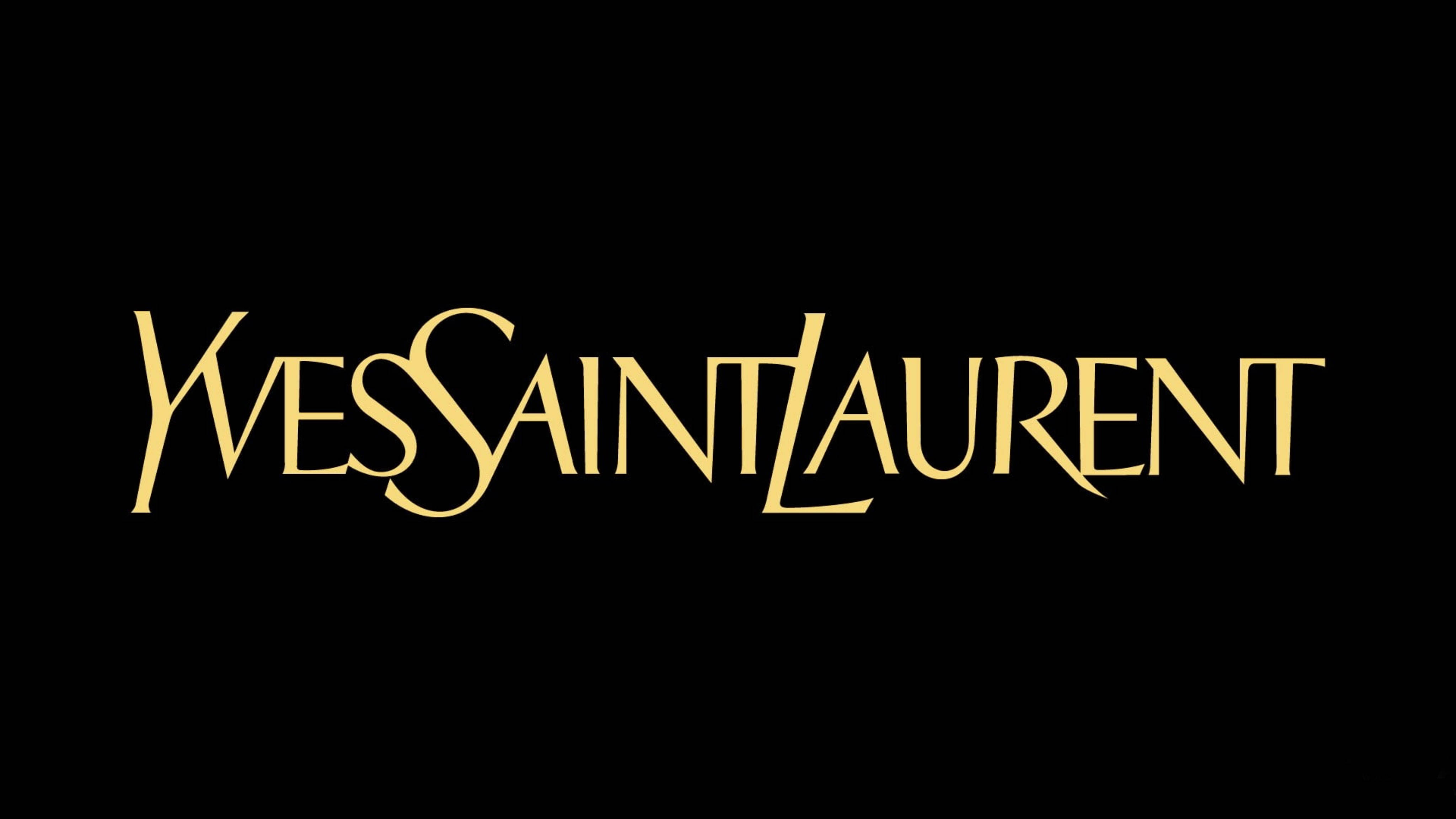 YSL 桌布 壁紙 — 金色 Yves Saint Laurent 標誌以優雅字體呈現於純黑背景上。
