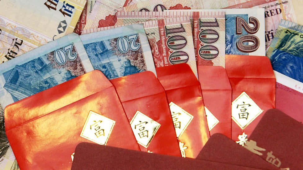 Red Envelope 桌布 壁紙 — 金色「福」字的紅色紅包放在散落的港幣鈔票上。