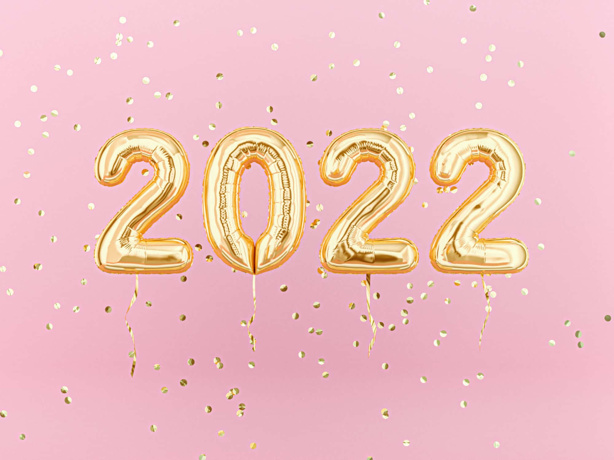 Balloon 桌布 壁紙 — 金色2022氣球漂浮在粉紅色背景上，散落著閃閃發光的五彩紙屑。