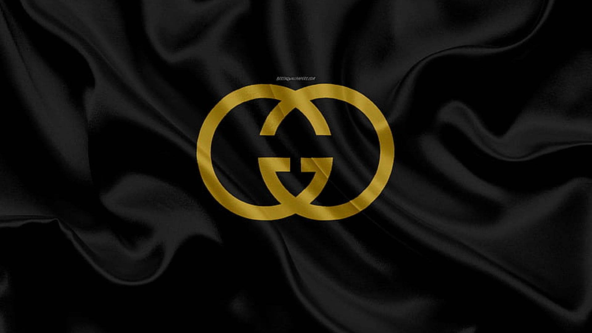 黑色緞面布料上的金色Gucci標誌，帶有褶皺