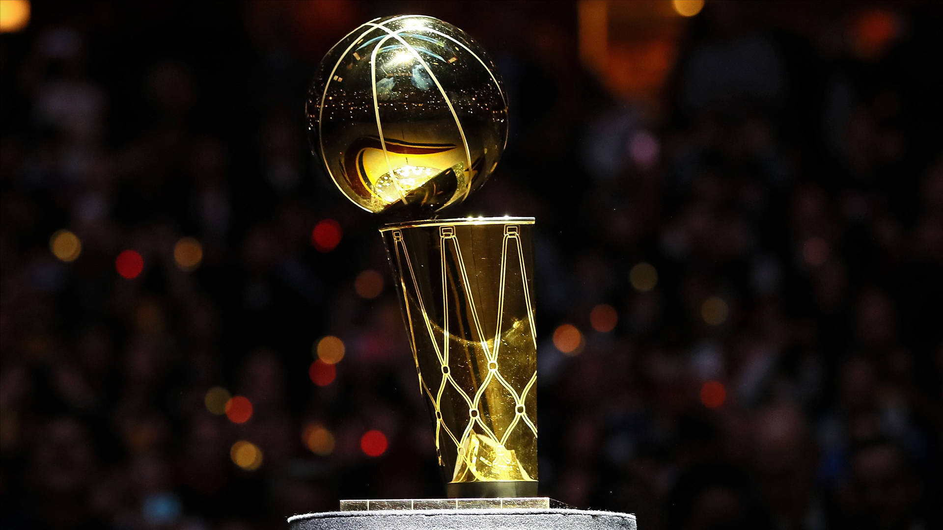 金色NBA冠軍獎盃在舞台上照亮，背景是人群散景。