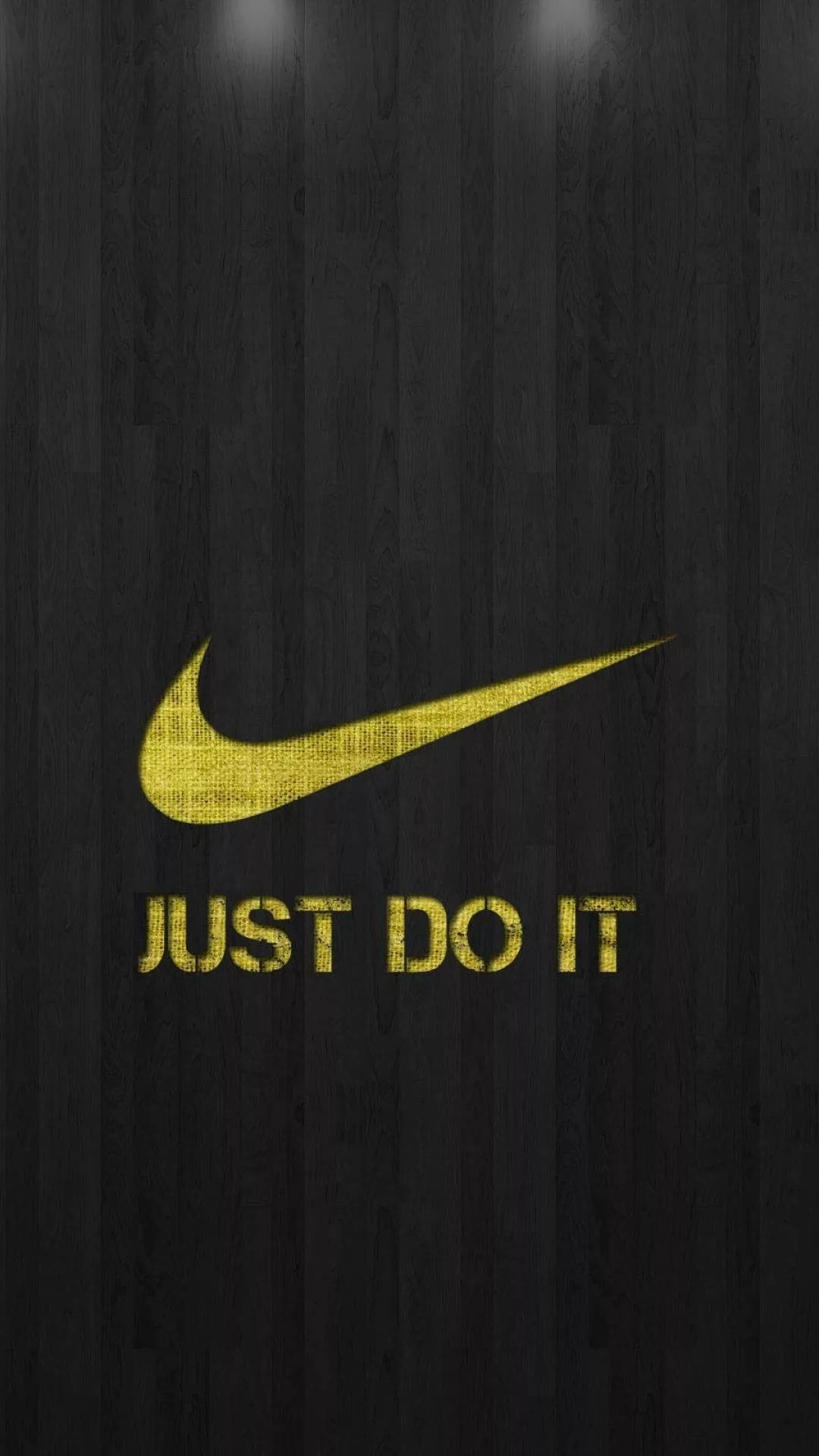 Nike iPhone 桌布 壁紙 — 金色Nike勾勾和「JUST DO IT」文字在深色木紋背景上發光。