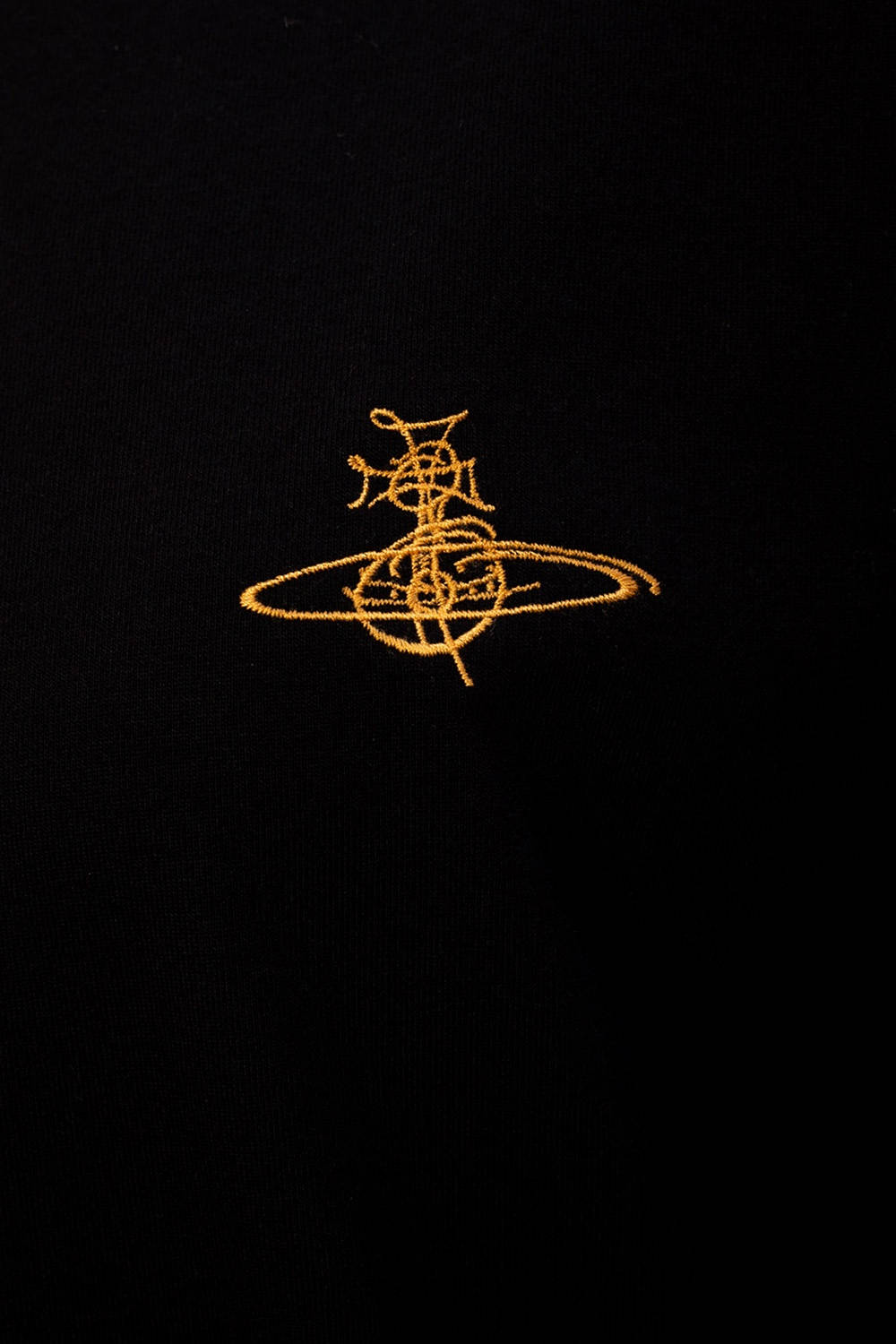 Vivienne Westwood 桌布 壁紙 — 金色Vivienne Westwood標誌刺繡在黑色布料上，帶有可見的縫線質感。