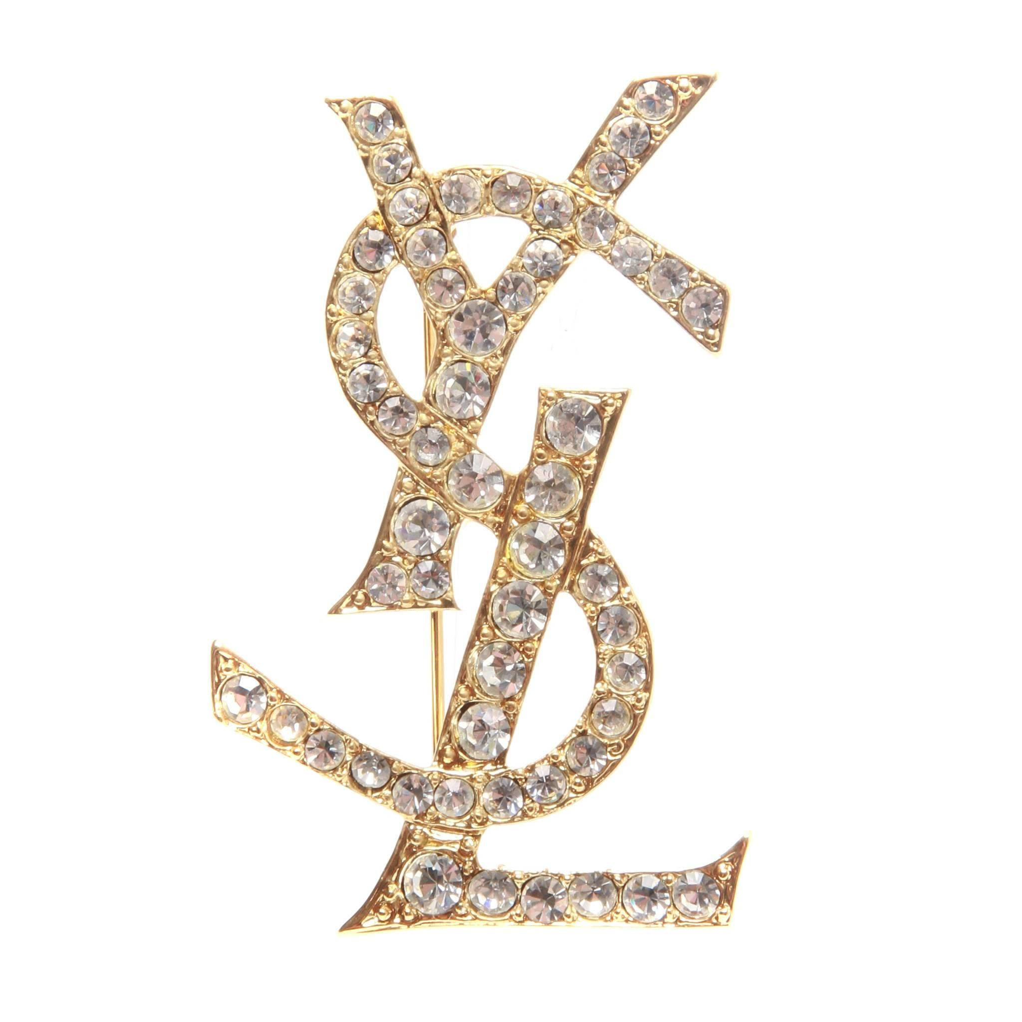 YSL 桌布 壁紙 — 金色YSL標誌胸針，飾有閃亮透明水晶，純白背景。