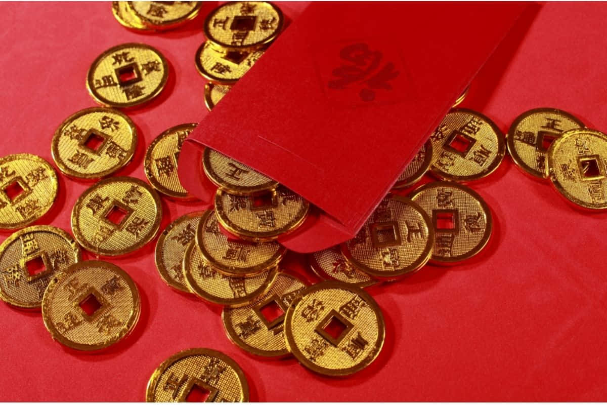 Red Envelope 桌布 壁紙 — 金色中國硬幣從紅色紅包中溢出，落在鮮紅色的表面上，象徵繁榮與慶祝。