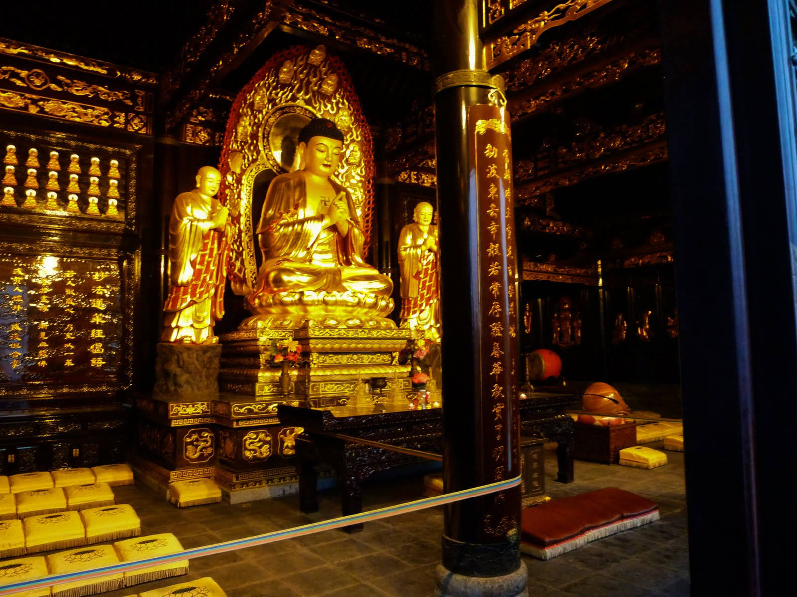 Statue Aesthetic 桌布 壁紙 — 金色佛像在裝飾華麗的寺廟聖殿中靜坐，周圍有精緻雕刻和溫暖的環境燈光。
