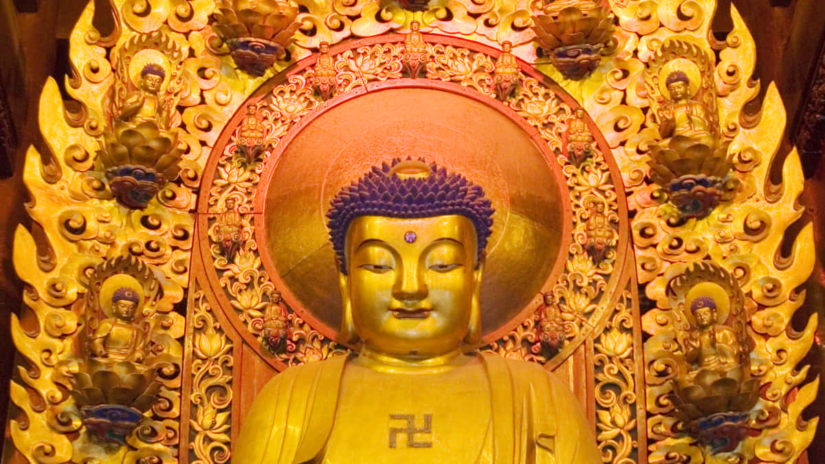 佛陀 桌布 壁紙 — 金色佛像表情祥和，端坐於華麗金色光環與火焰狀雕刻中央。