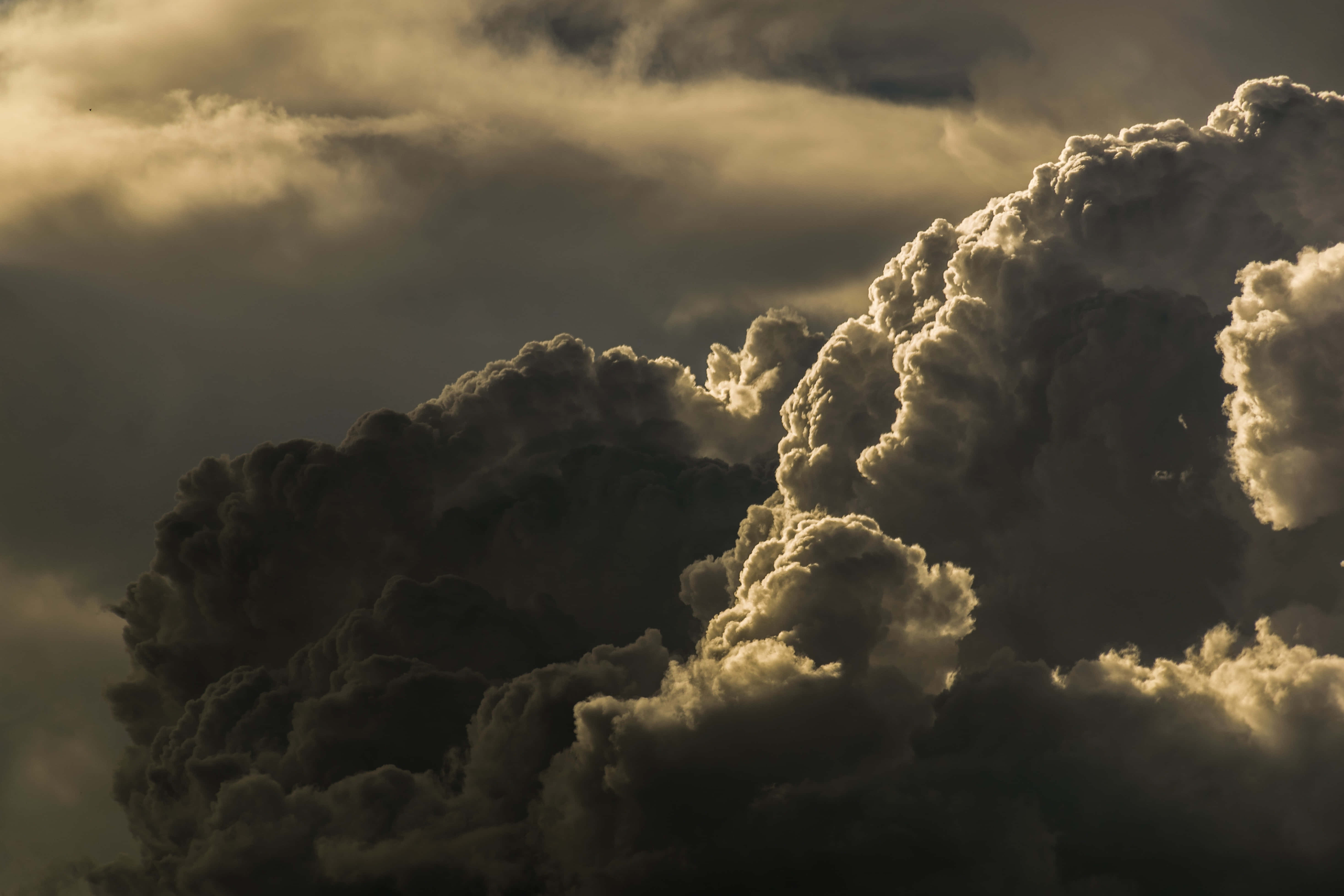 Aesthetic Cloud 桌布 壁紙 — 金色光線照射下的戲劇性雲層，營造出充滿氛圍且富有紋理的天空，帶有深邃陰影和明亮高光。