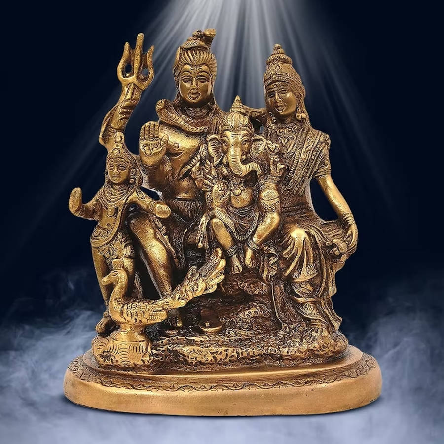 Shiv Parivar 桌布 壁紙 — 金色印度教神像，包含濕婆、帕爾瓦蒂、象頭神及孩童形象，在戲劇性聚光燈下，背景黑暗煙霧瀰漫。