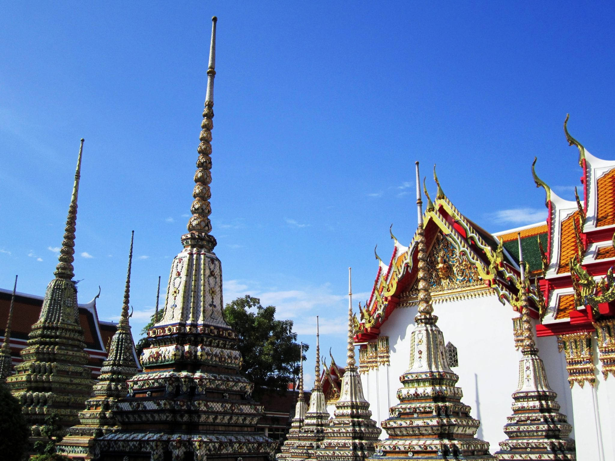 Bangkok 桌布 壁紙 — 金色和白色華麗的寺廟尖塔在晴朗的藍天下聳立於充滿活力的泰國佛教建築群中。