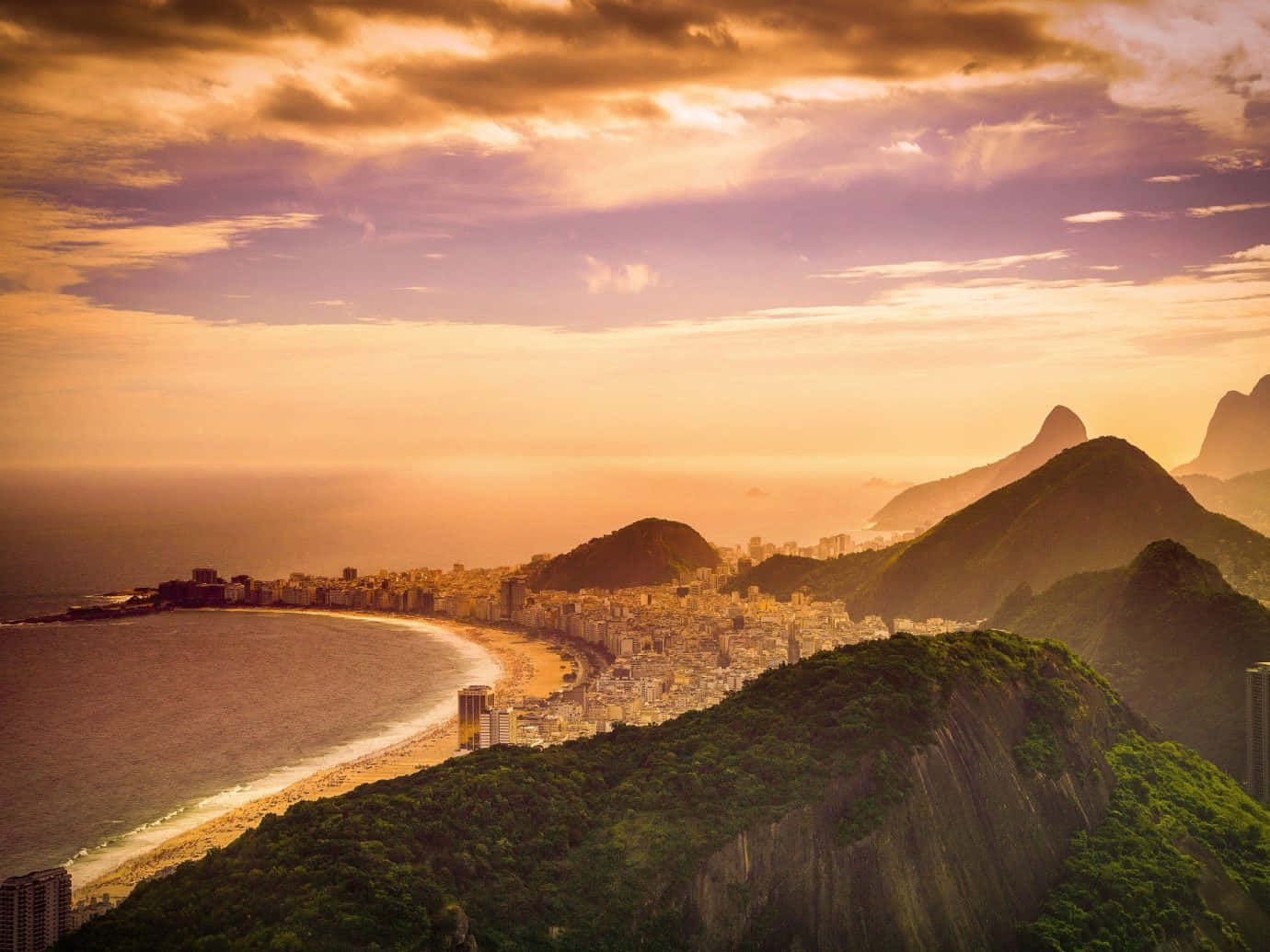 Brazilian Beach 桌布 壁紙 — 金色夕陽以溫暖光線沐浴里約熱內盧的標誌性海岸線和甜麵包山。