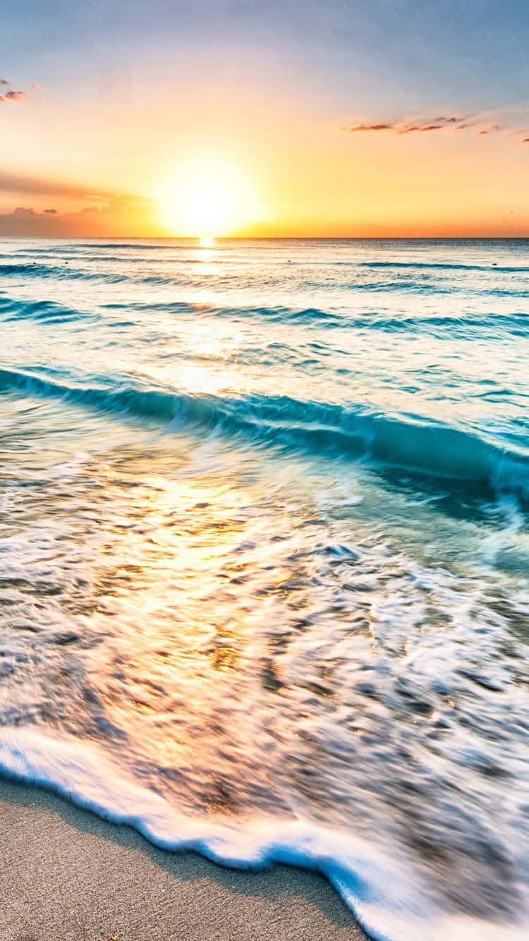 桌布 壁紙 — 金色夕陽將溫暖的光芒投射在湧向沙灘的碧綠海浪上。