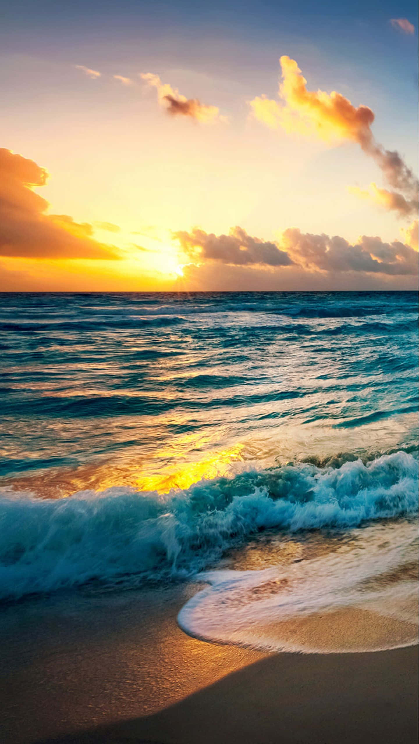 海灘 桌布 壁紙 — 金色夕陽描繪著海浪拍打沙灘，上方有火燒雲。