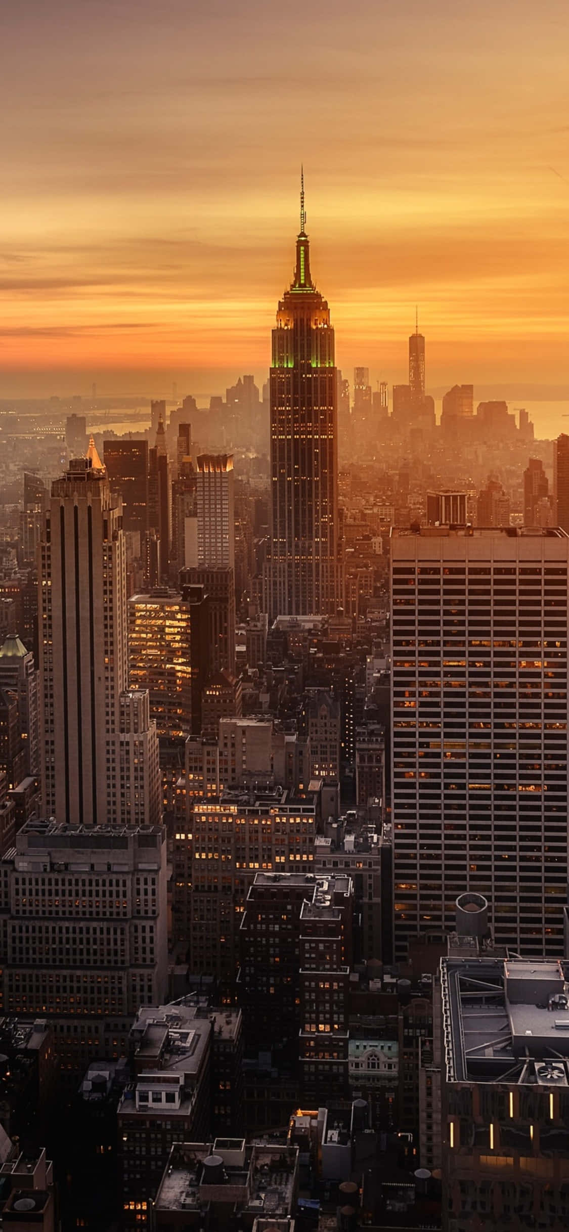 New York 桌布 壁紙 — 金色夕陽沐浴帝國大廈和紐約天際線，溫暖琥珀色光芒中城市燈光開始閃爍。