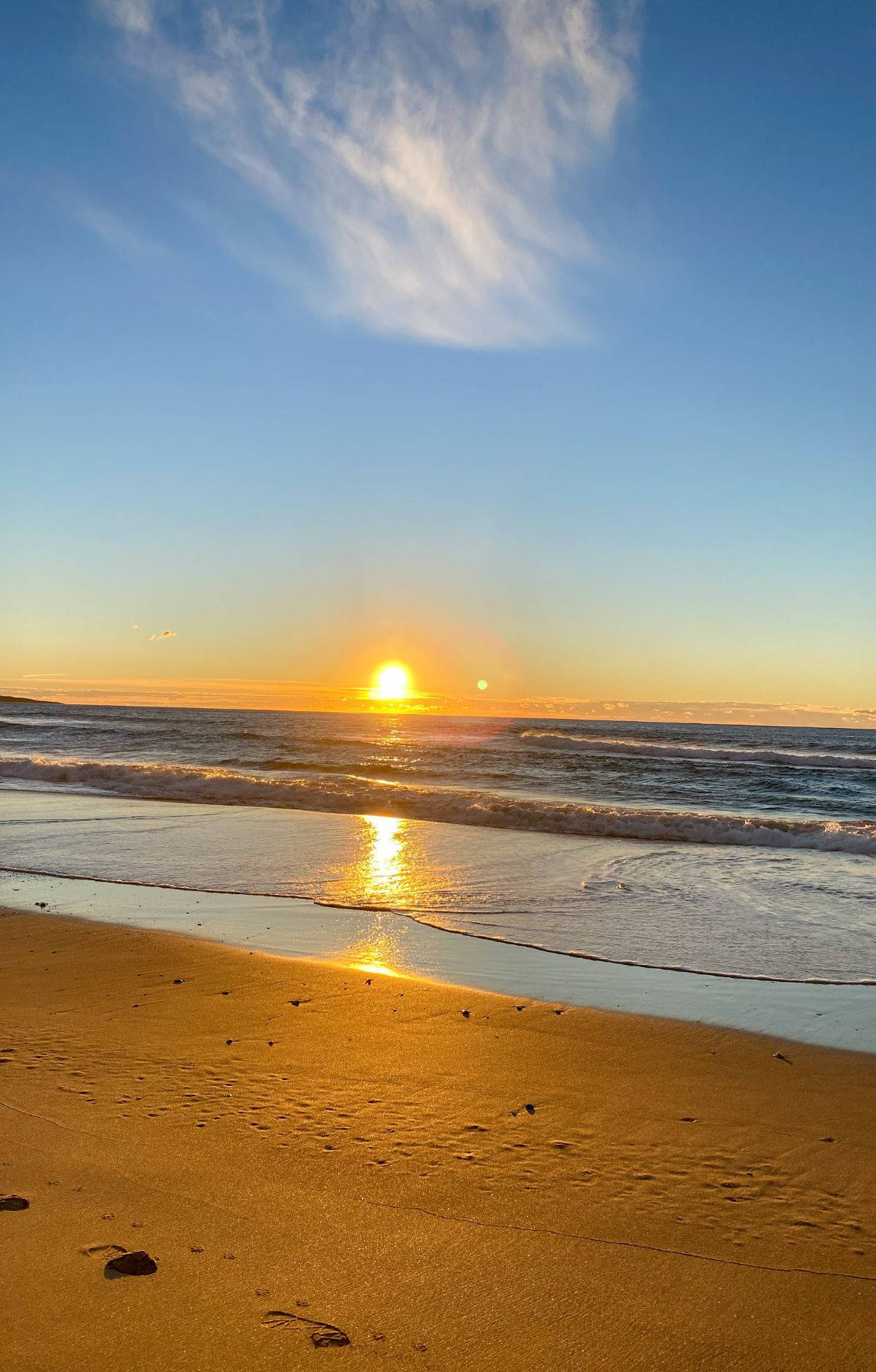 夕陽下的海洋，沙灘上有海浪 — 日出 GIF 壁紙