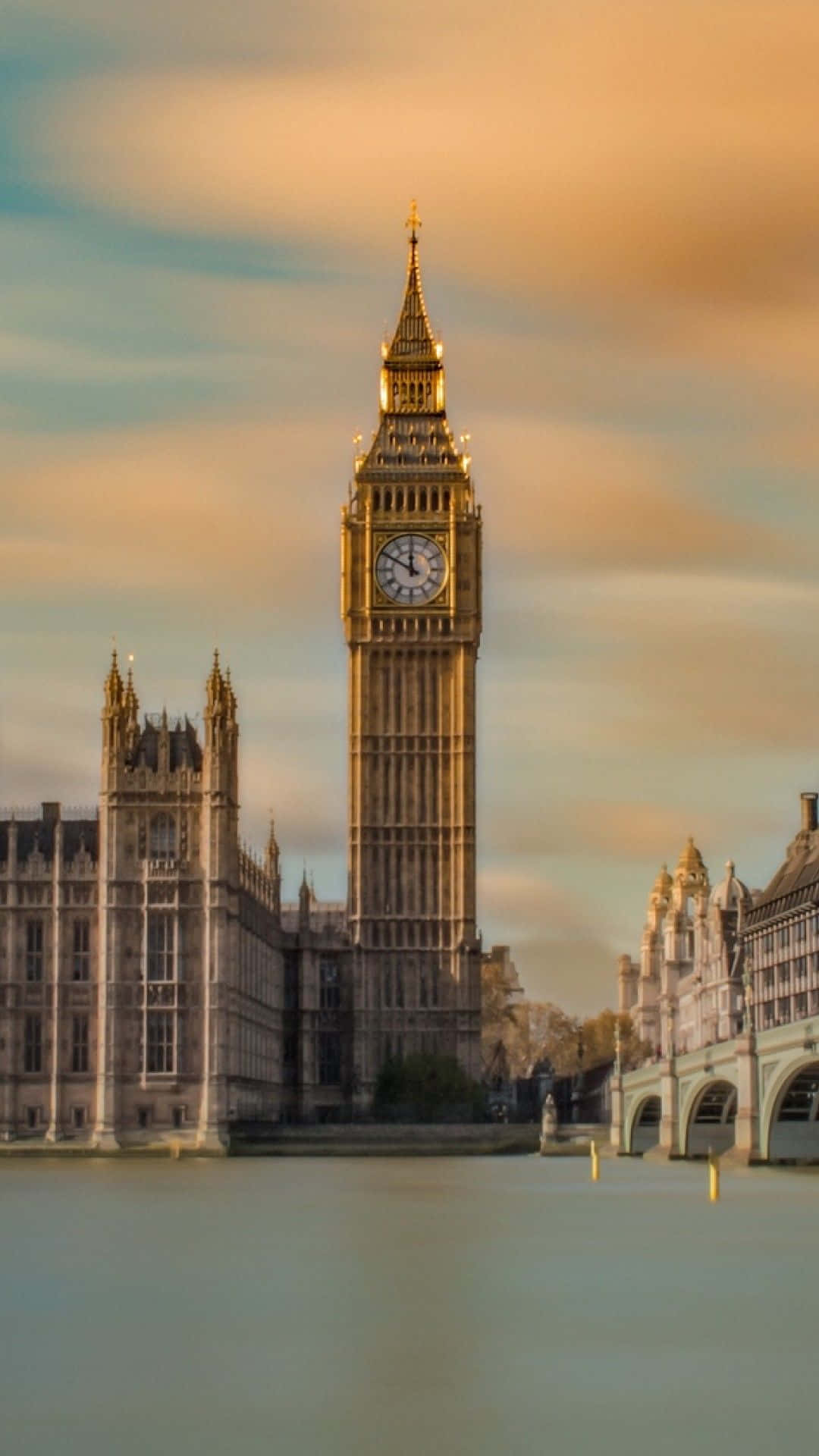 London iPhone 桌布 壁紙 — 金色大笨鐘鐘樓在日落時分高聳於泰晤士河上，軟雲和歷史建築盡收眼底。