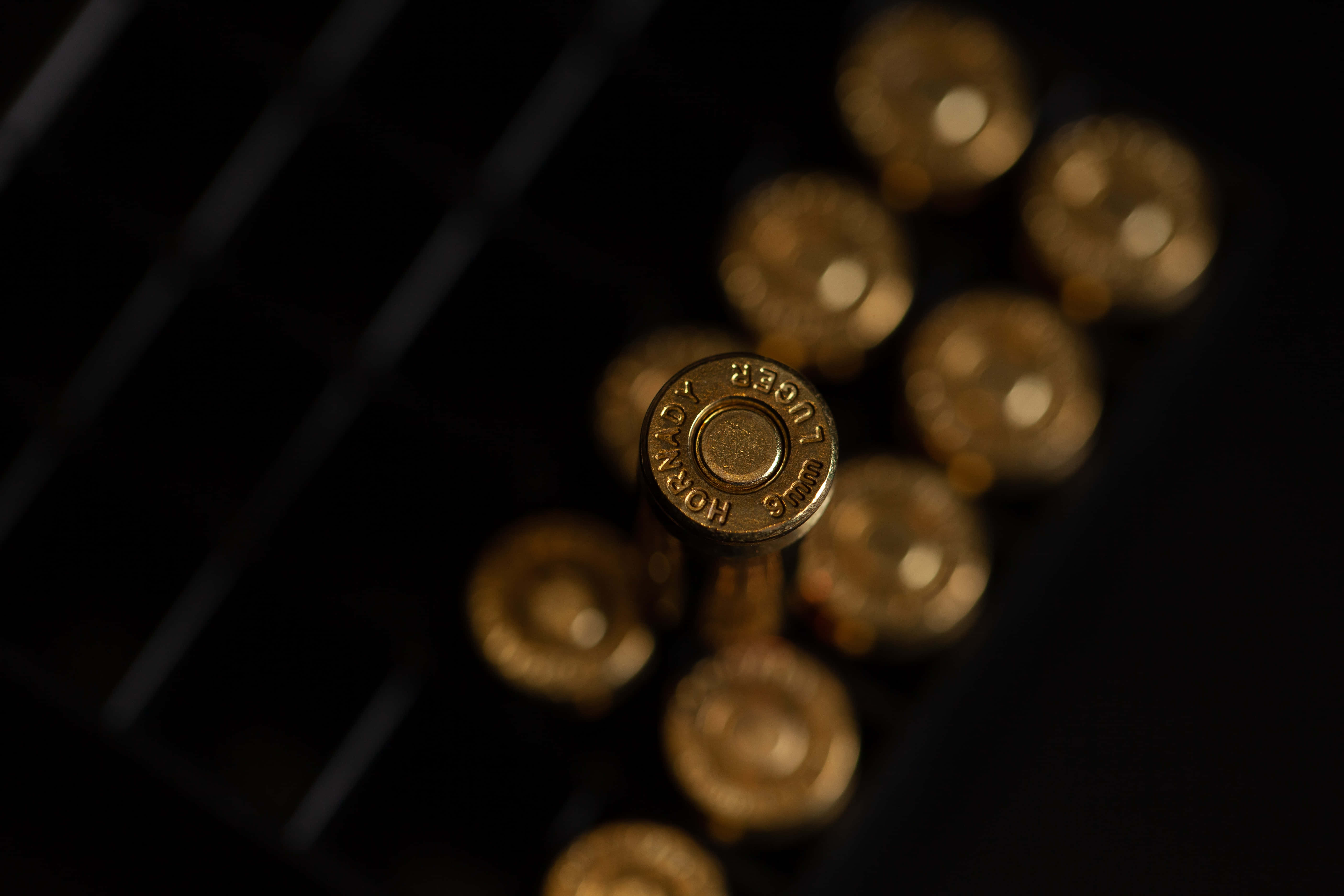bullet 桌布 壁紙 — 金色子彈殼排列在深色網格上，景深較淺，光線戲劇化。
