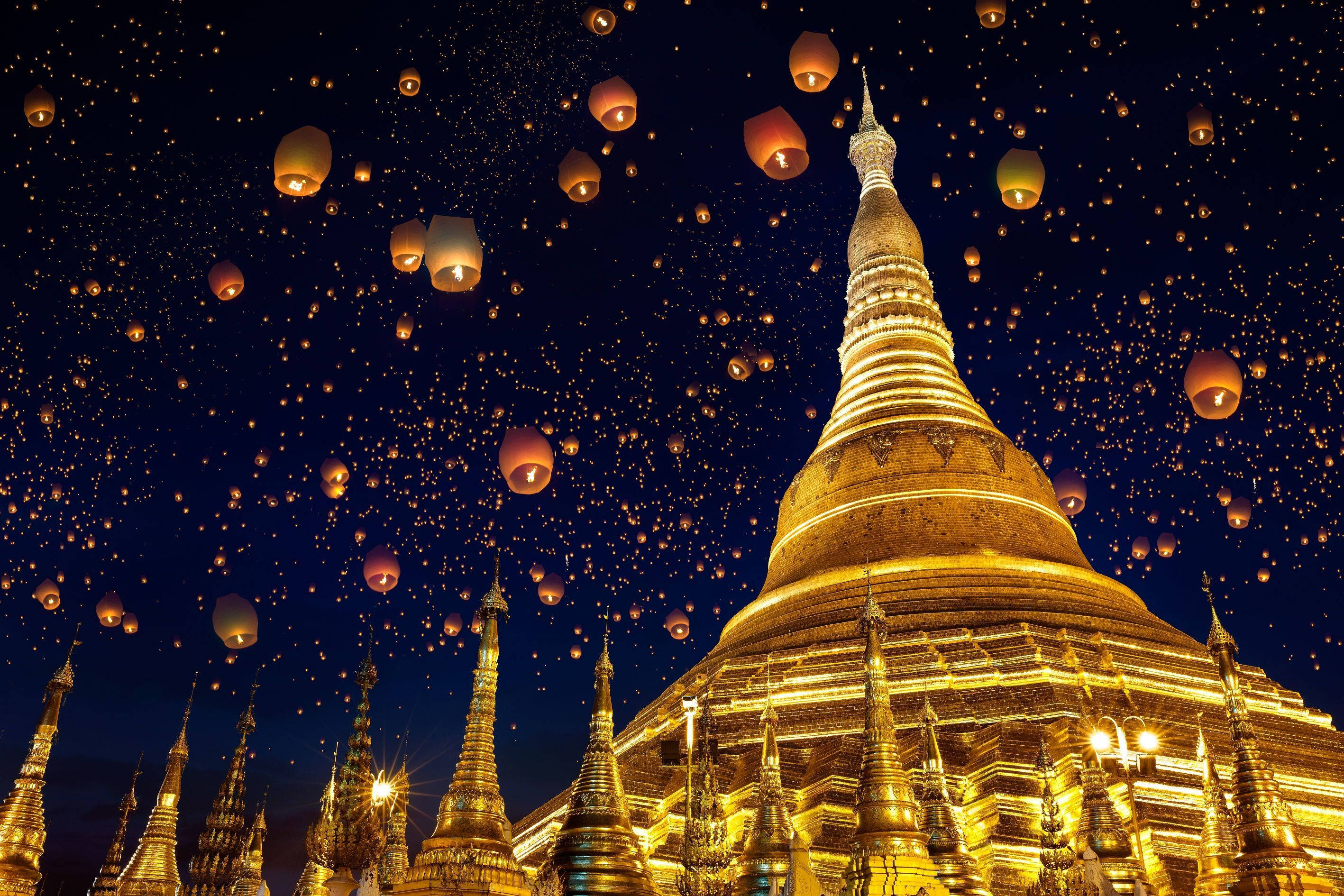 Yangon 桌布 壁紙 — 金色寶塔在充滿數千盞漂浮天燈、散發溫暖光芒的夜空下閃耀。