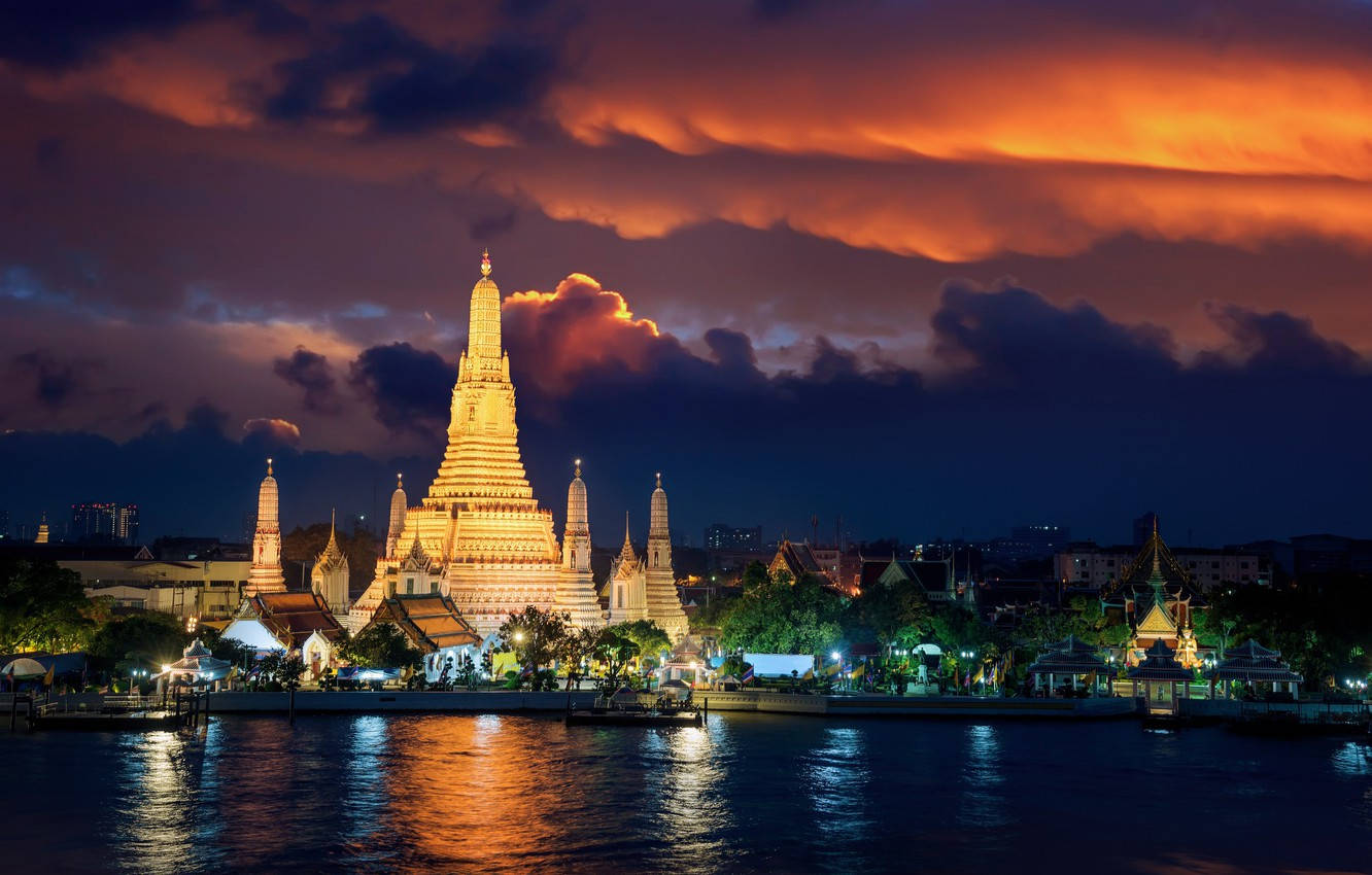 Yangon 桌布 壁紙 — 金色寺廟尖塔在平靜河水倒映的熾熱暮色天空中閃耀。