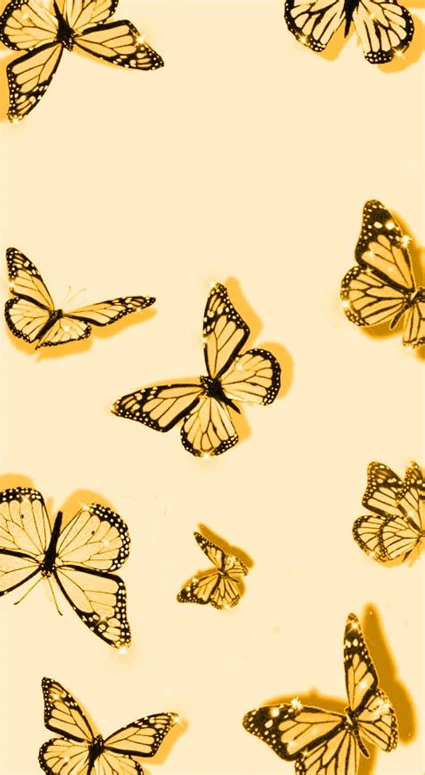 Butterflies 桌布 壁紙 — 金色帝王蝶帶黑色脈絡，在柔和的奶油色背景上優雅飄浮。