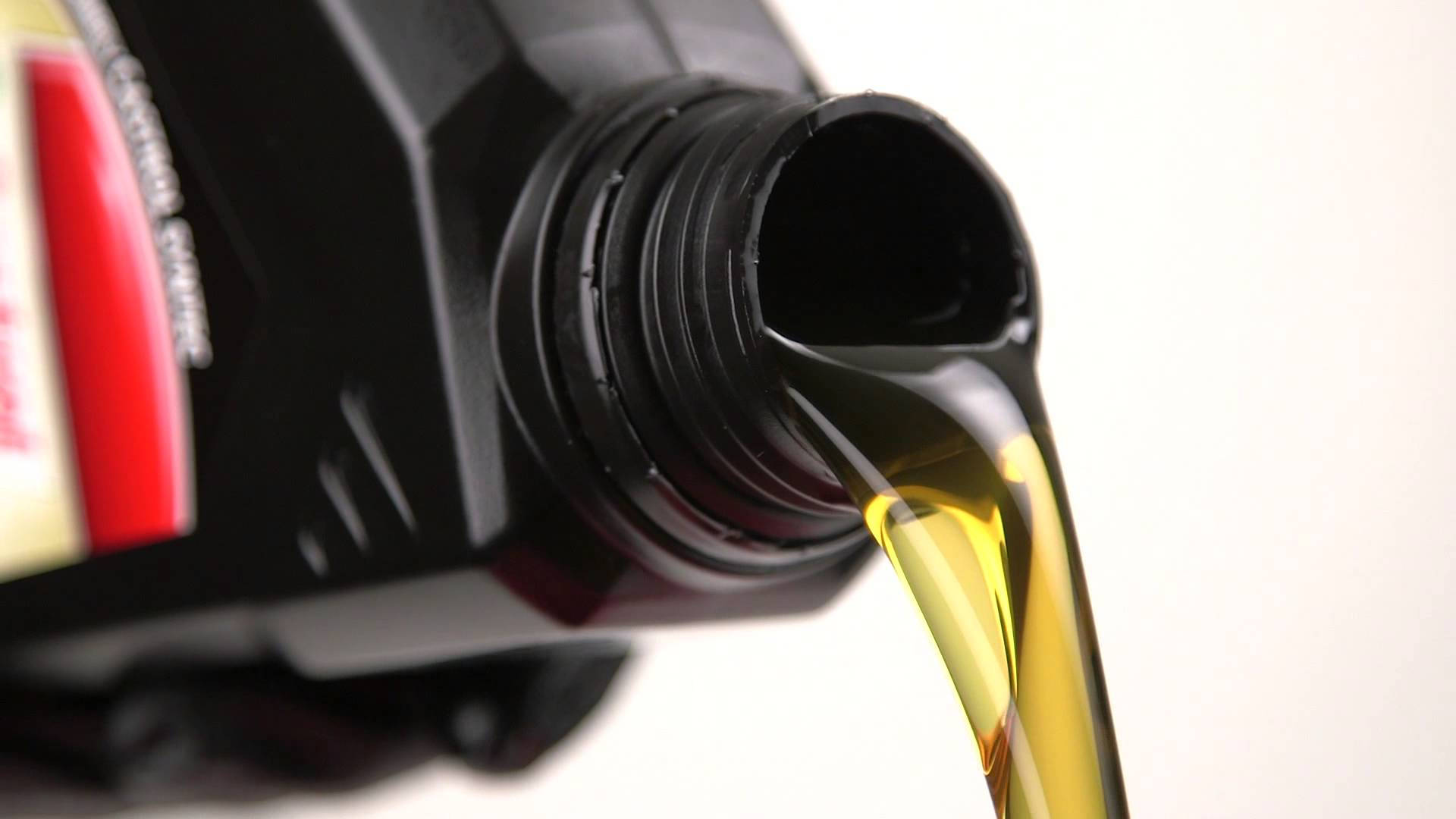 Oil 桌布 壁紙 — 金色引擎機油從黑色瓶子中順暢流出，背景為潔淨的白色。