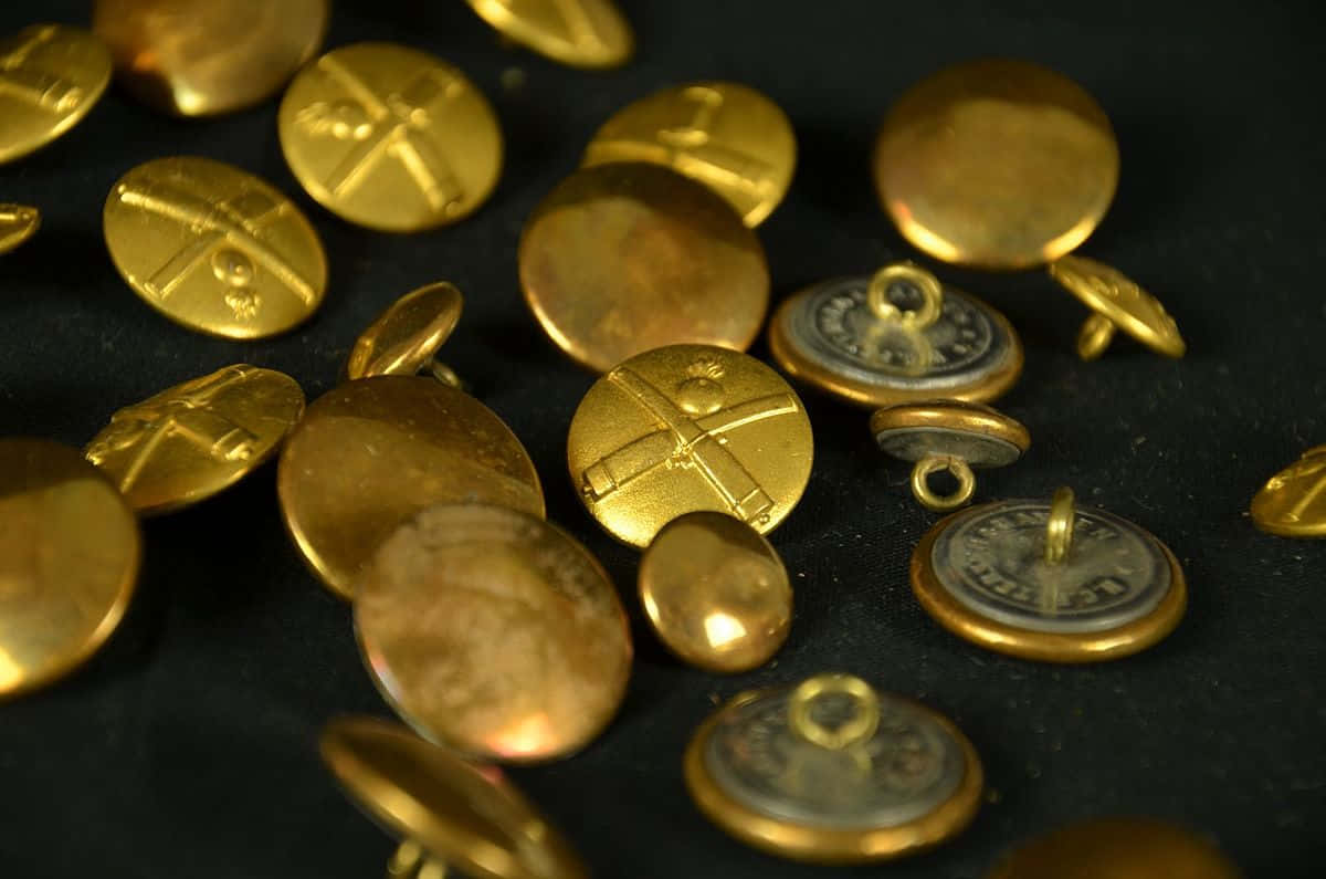 Buttons 桌布 壁紙 — 金色復古鈕扣帶有雕刻十字圖案，散落在深色紋理表面上。