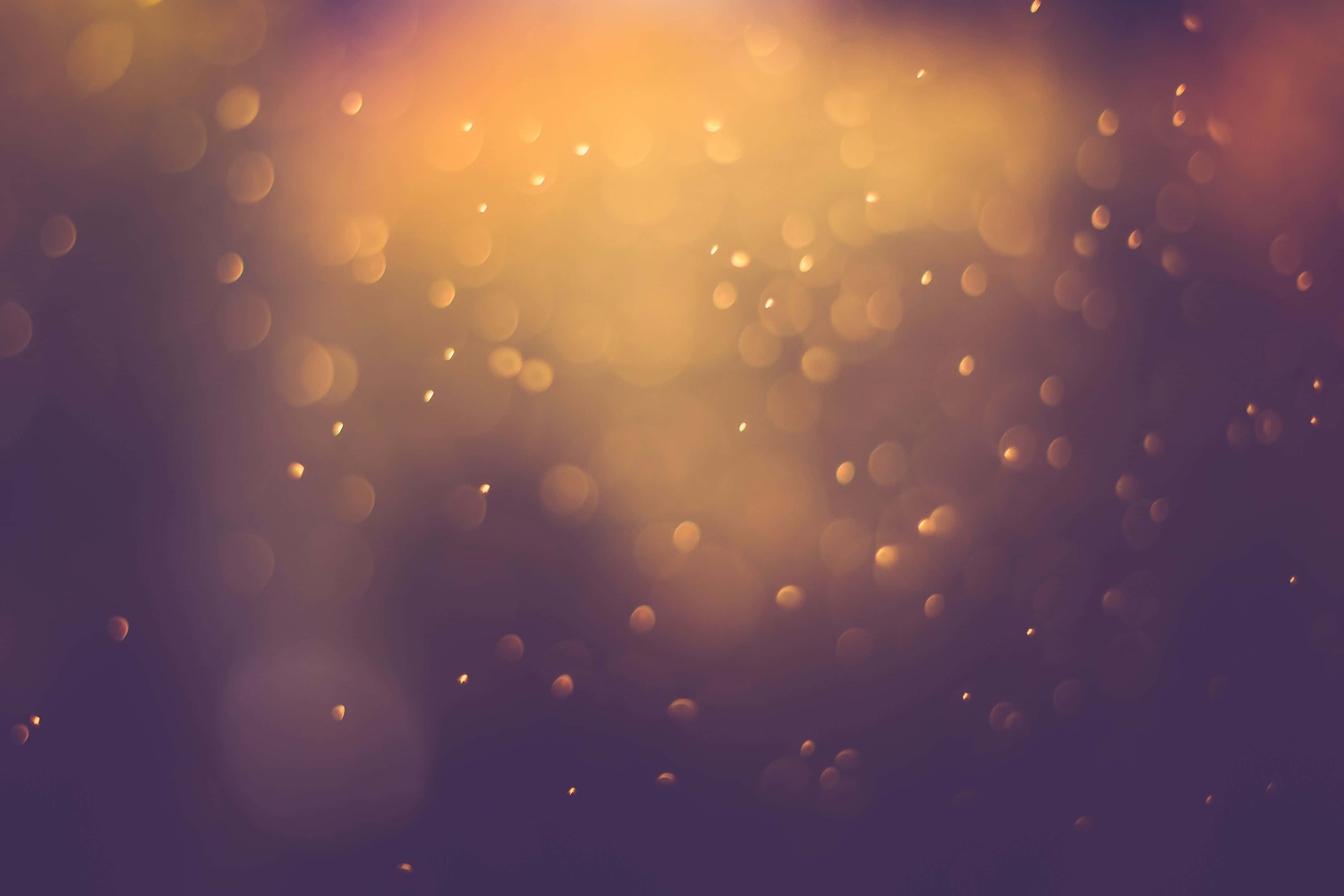 Light Effect 桌布 壁紙 — 金色散景燈光在深紫色背景下閃爍，營造出夢幻而溫暖的抽象光芒。