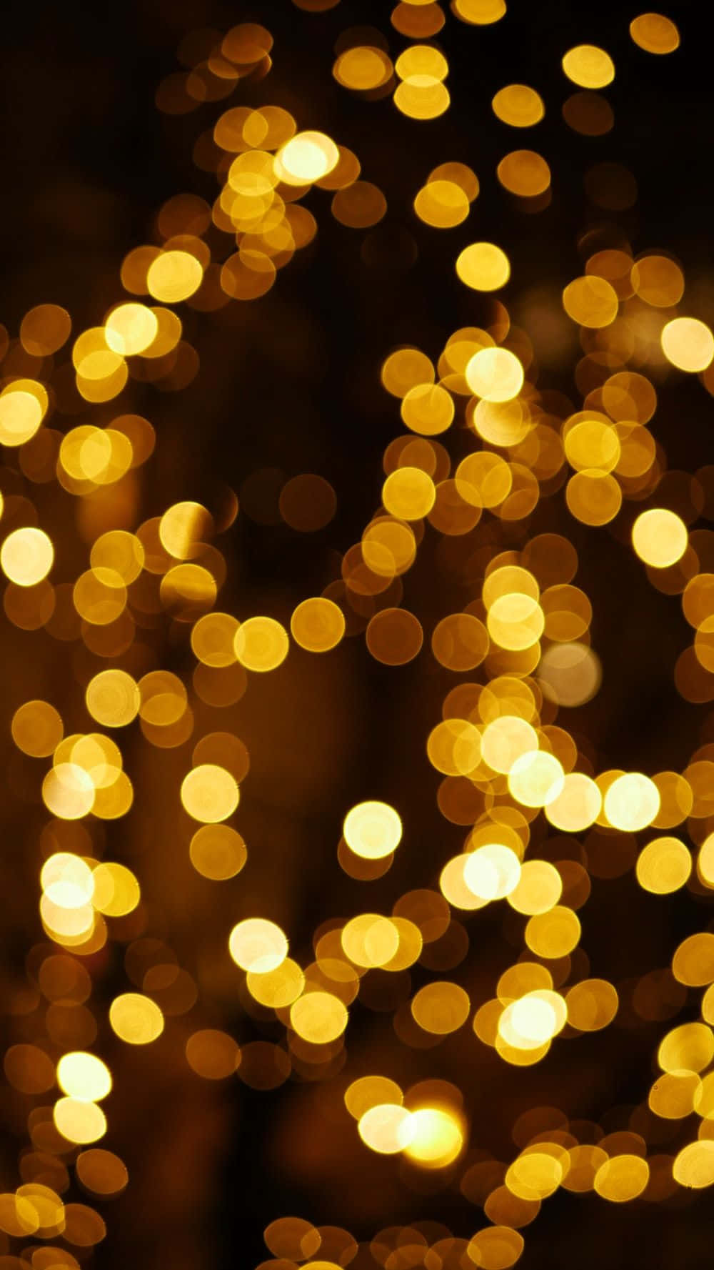 Christmas Light 桌布 壁紙 — 金色散景燈光在深色背景上閃爍，營造出溫暖的節日光芒。
